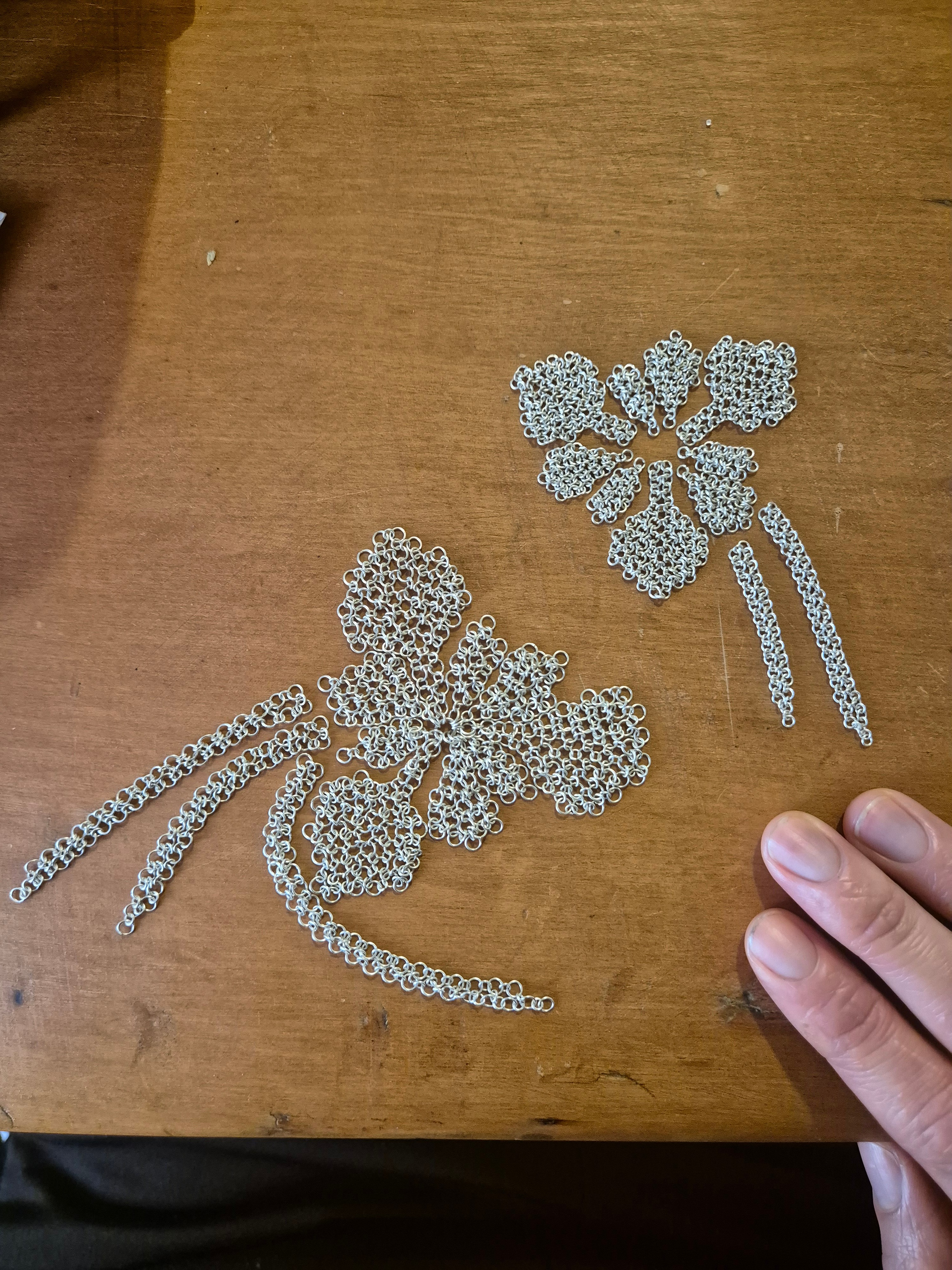 Delicate floral chainmail forms arranged on top of a bench