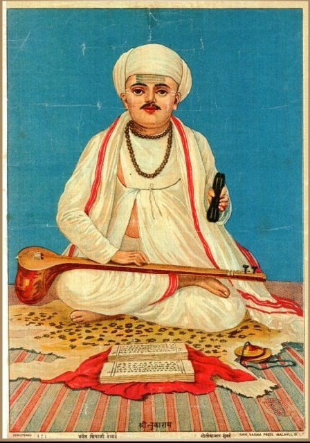 Tukaram, dressed in white, sits cross-legged with his instruments.