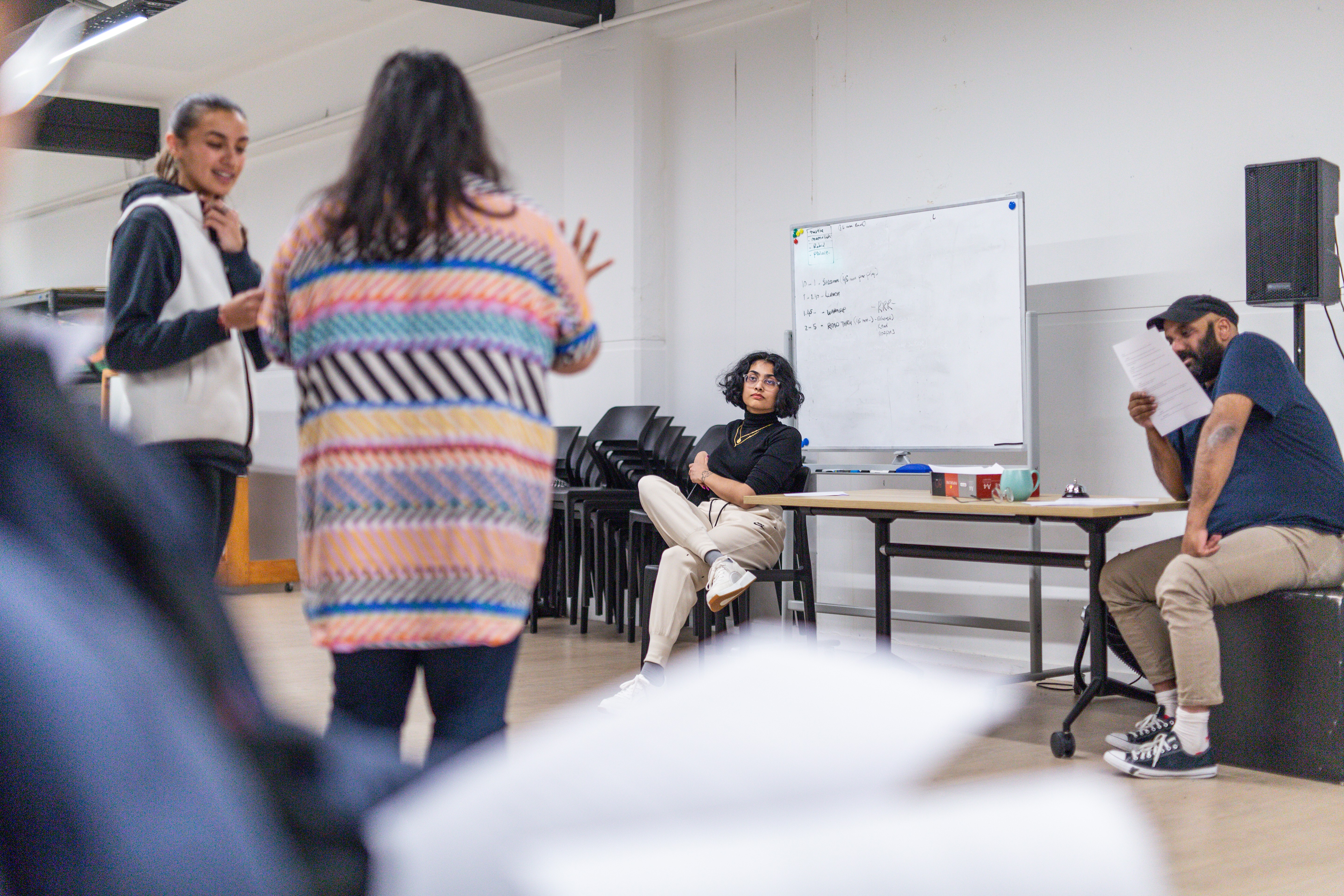 People standing and sitting in a rehearsal space