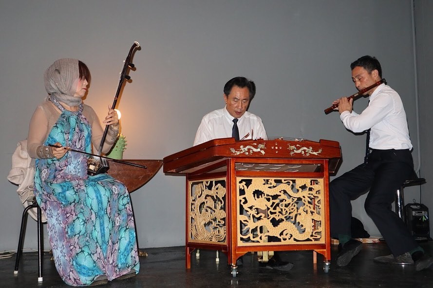 Three asian musicians playing traditional Chinese instruments