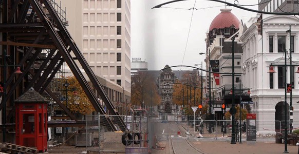 In a scene from the film ‘Moving’, the camera points down a deserted Christchurch city street barricaded by fences. A cathedral can been seen in the distance.