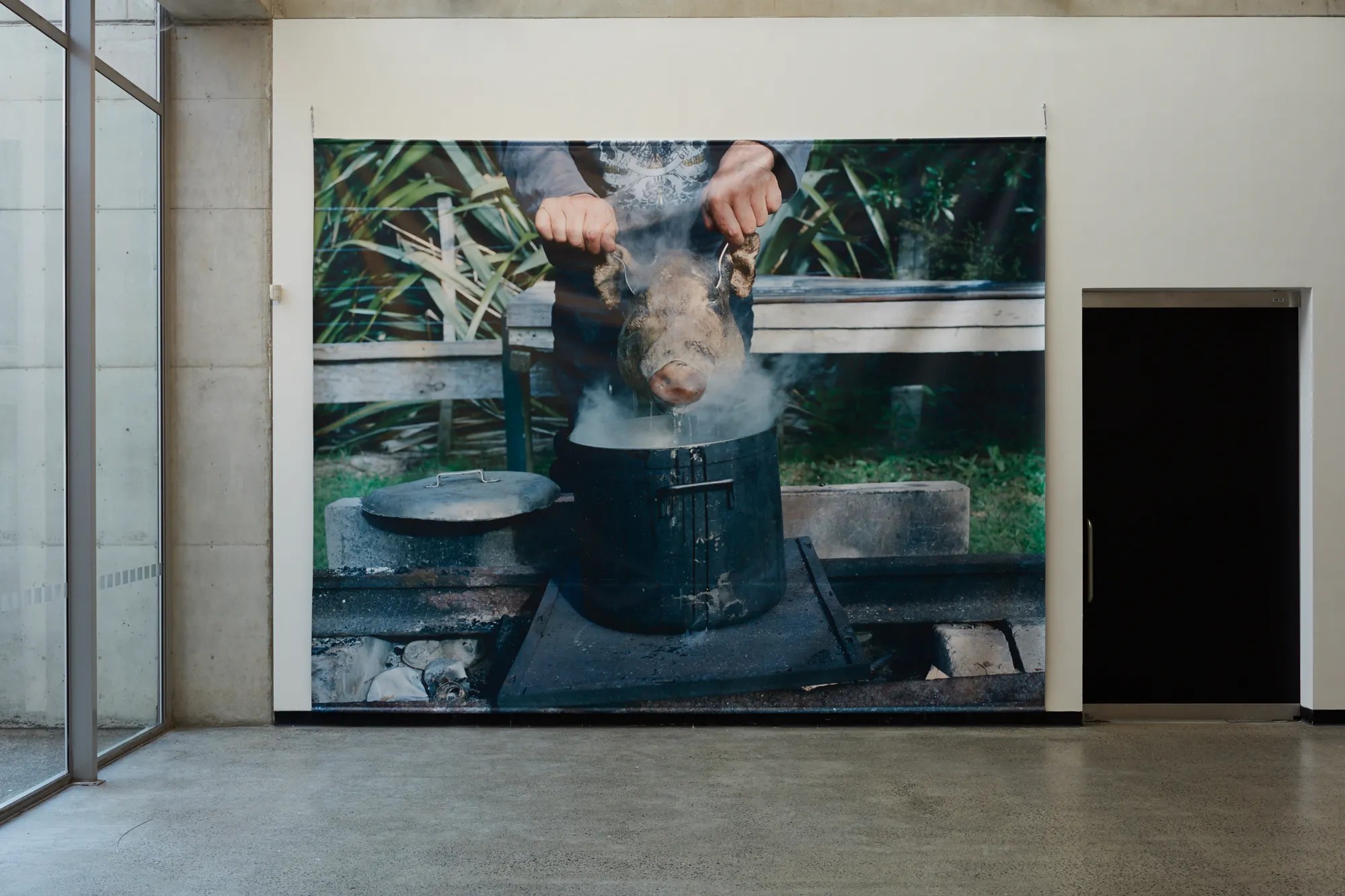 Wall with a vinyl of a pig head being lowered into a steaming pot