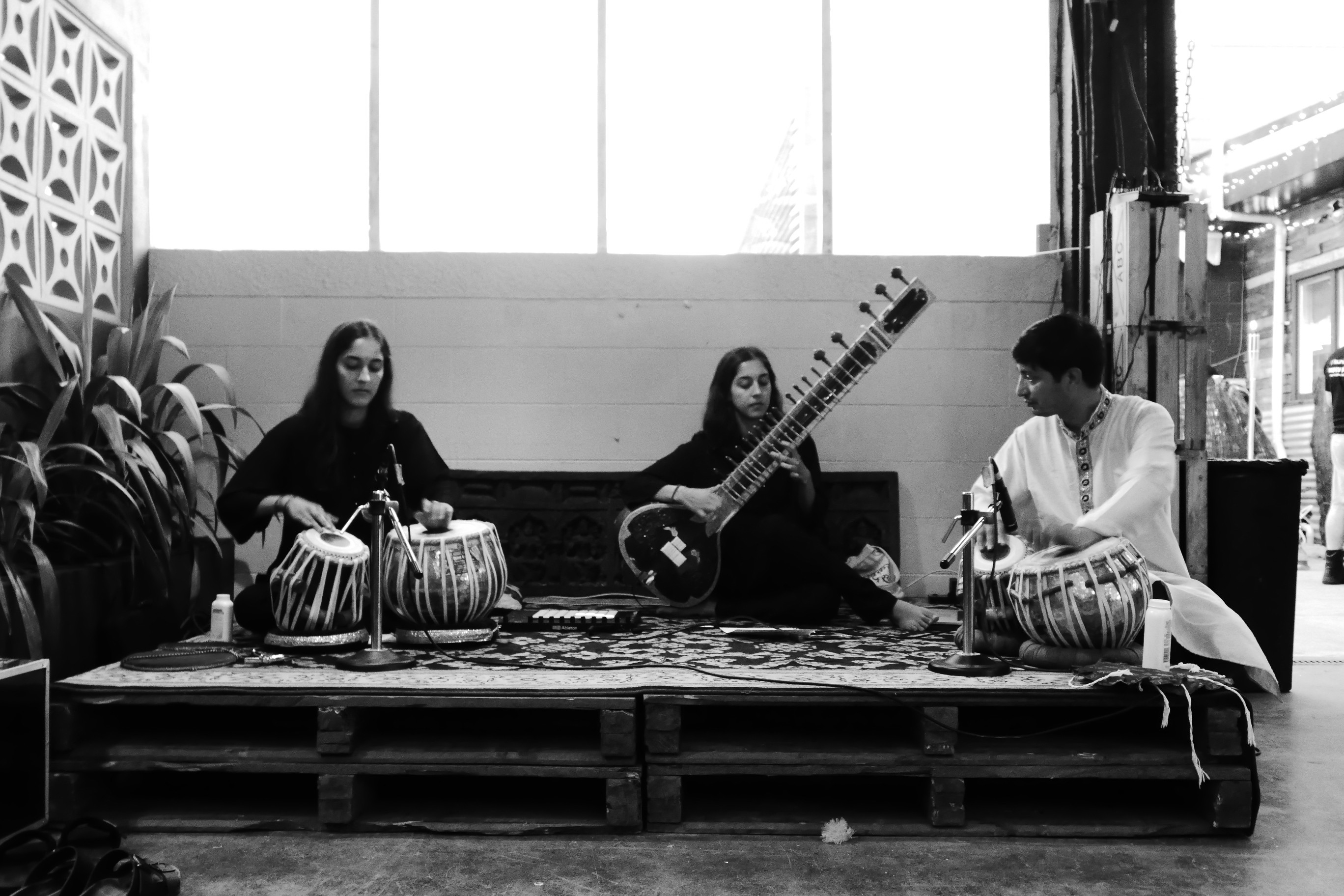 Three people performing with Indian instruments