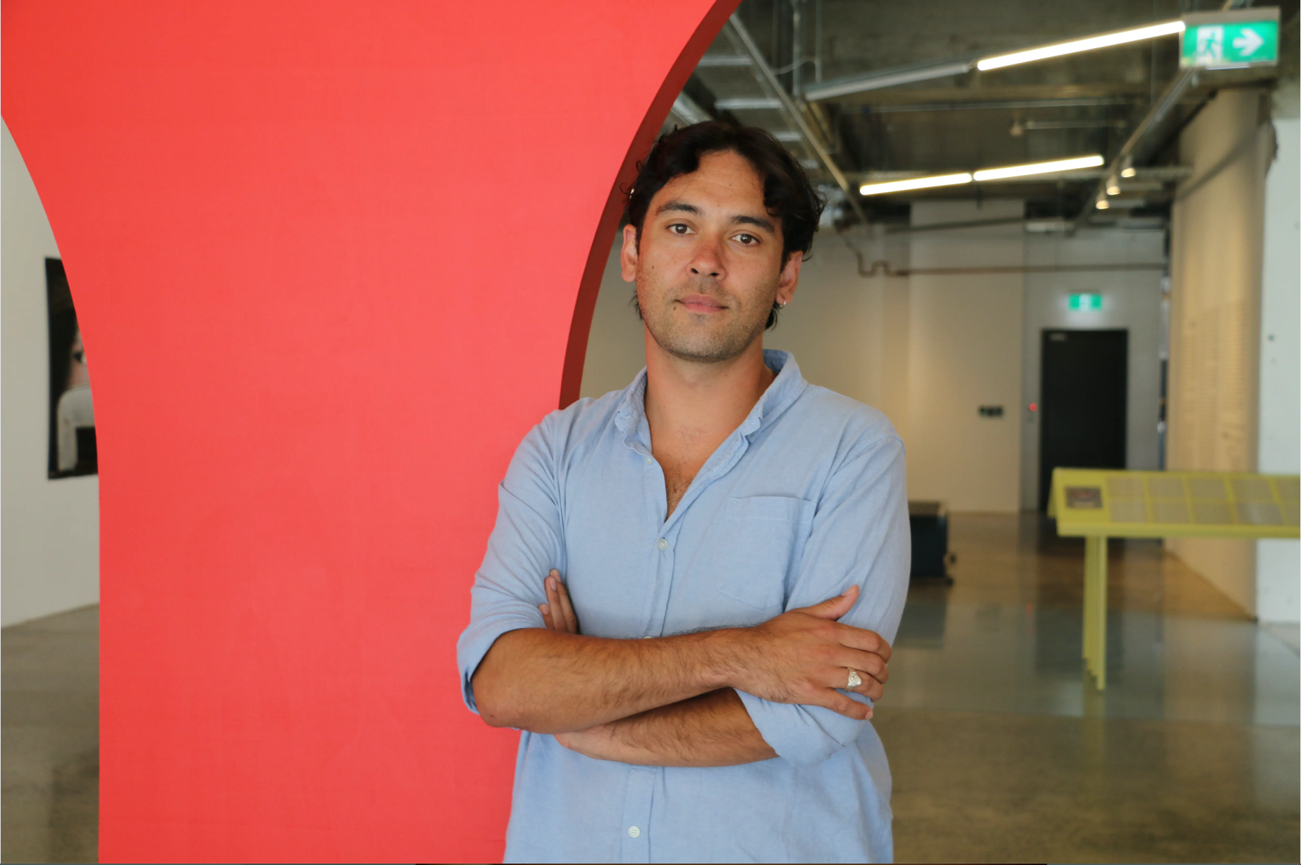 Short haired man with crossed arms looking at the camera.