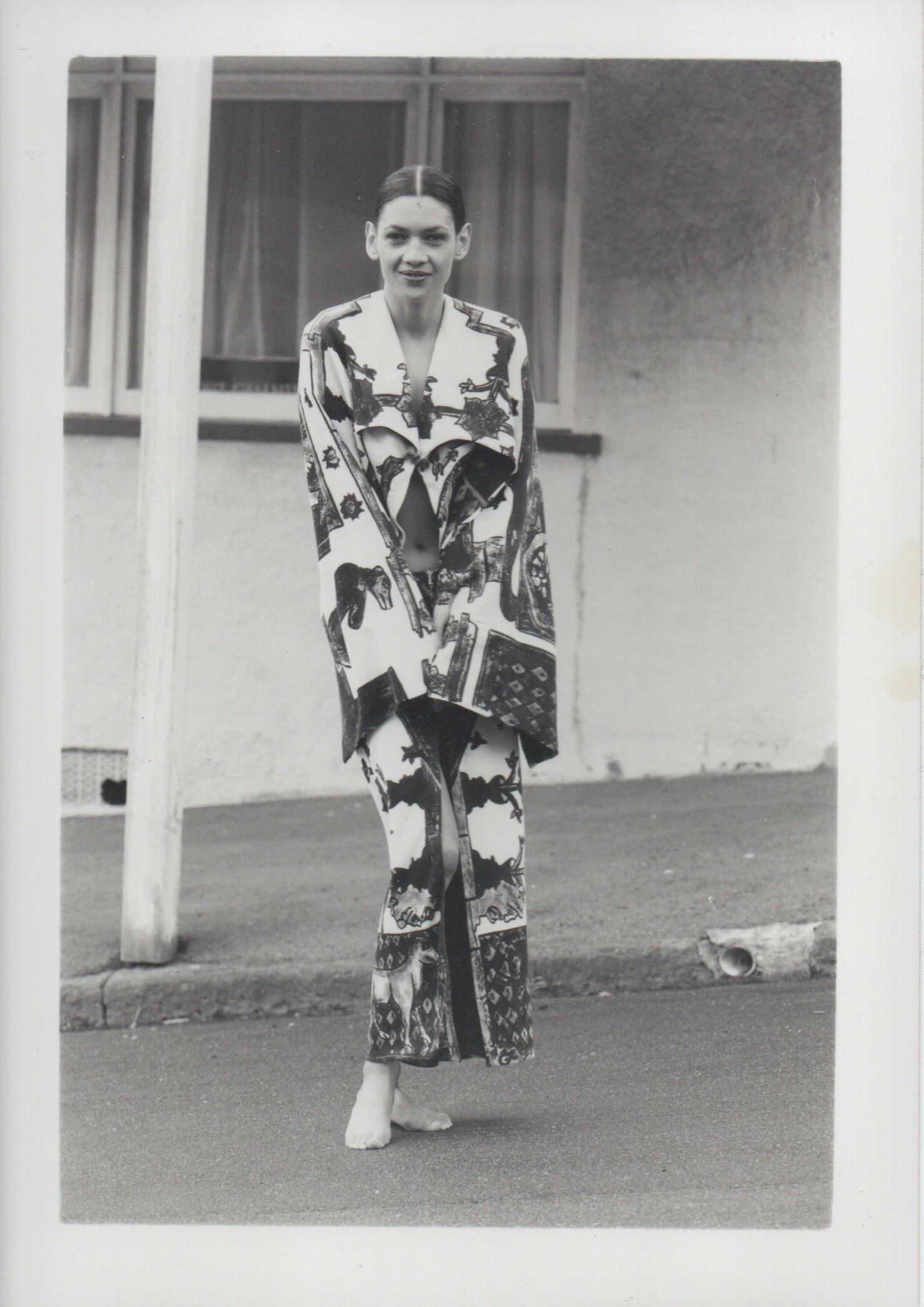 A black and white photo of a woman in a dramatically-patterned outfit