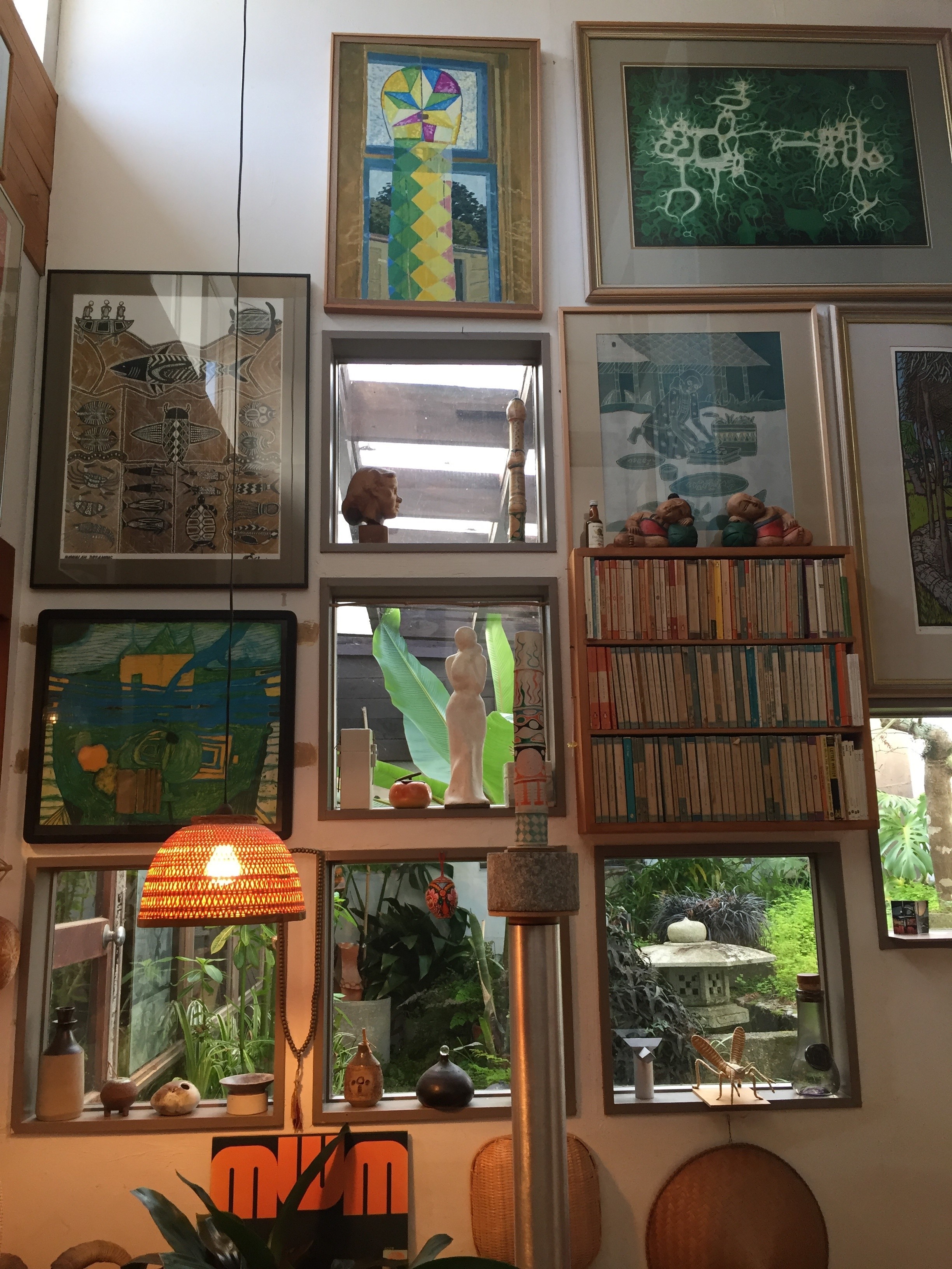 Framed pictures hung close together and surrounded by other collected objects