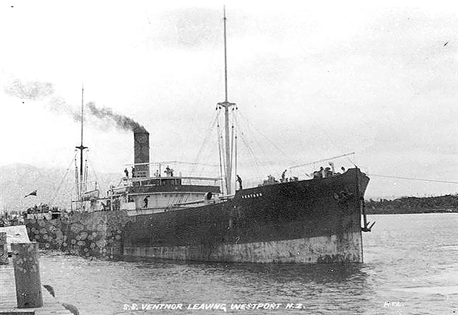 A ship at the port with smoke rising out its chimney