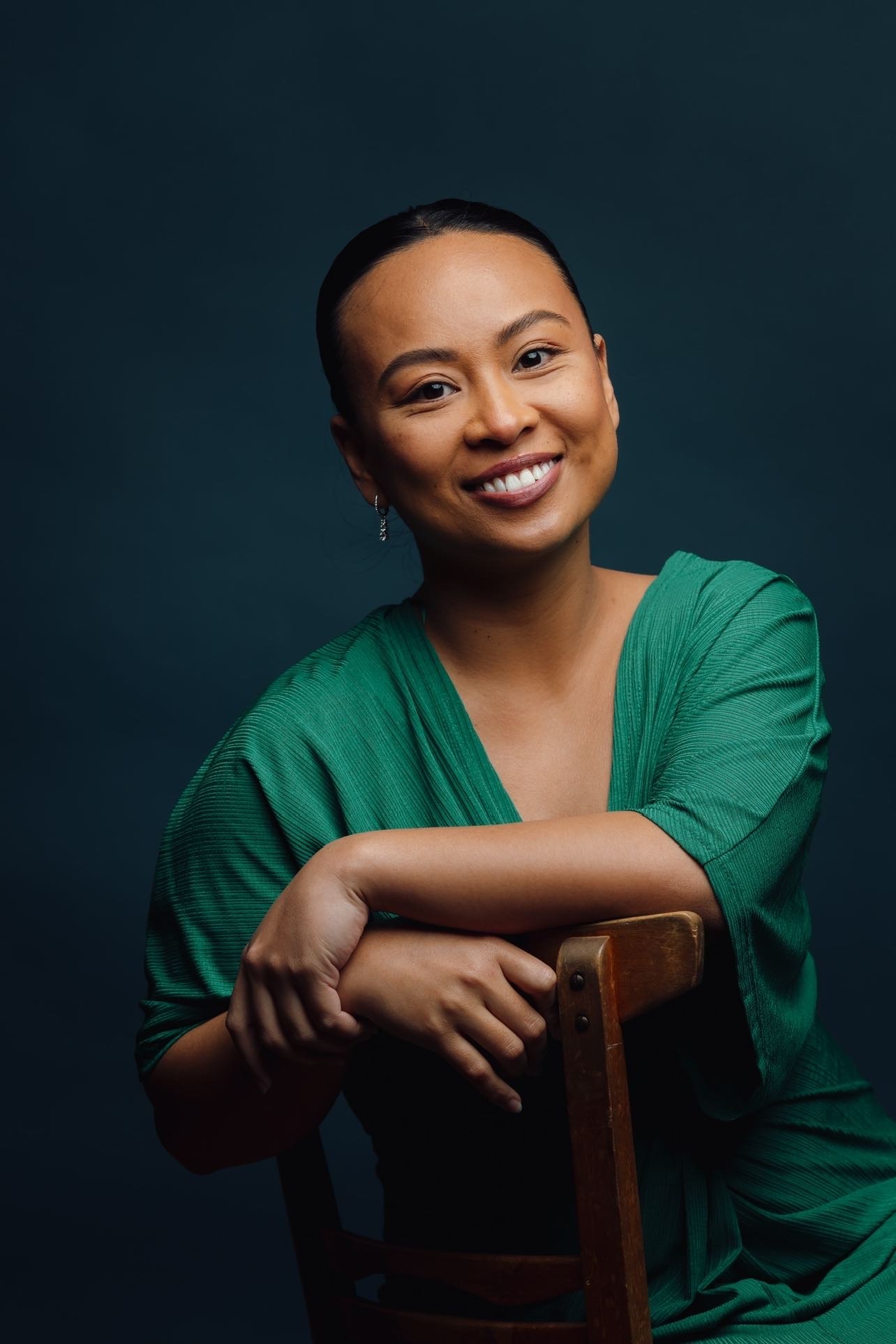 Person of Filipino descent in a green top against a blue background