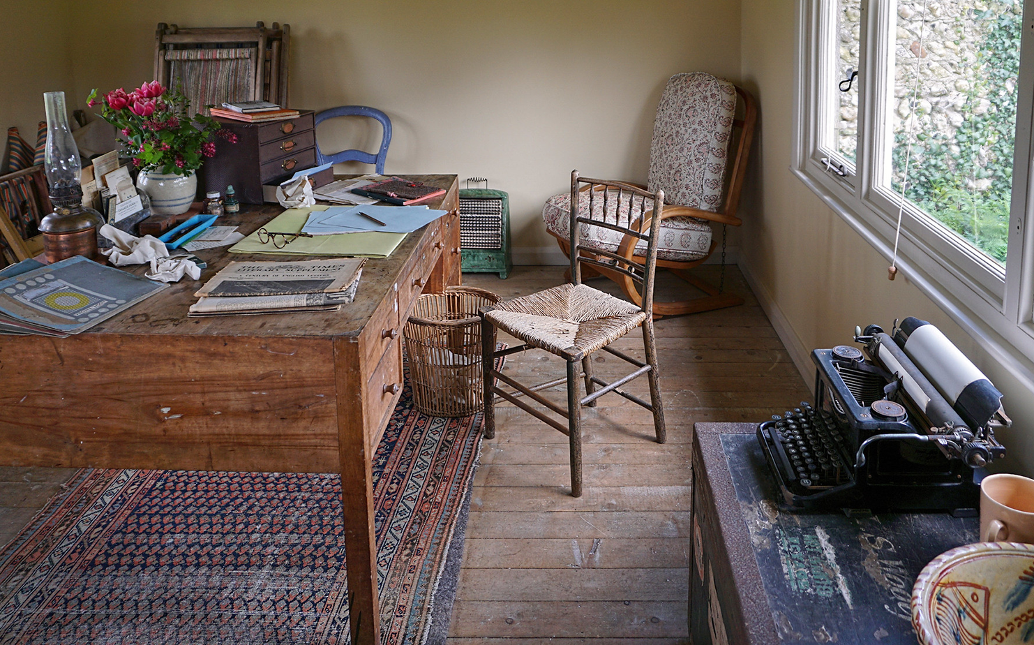 A messy desk with papers and a typewriter.