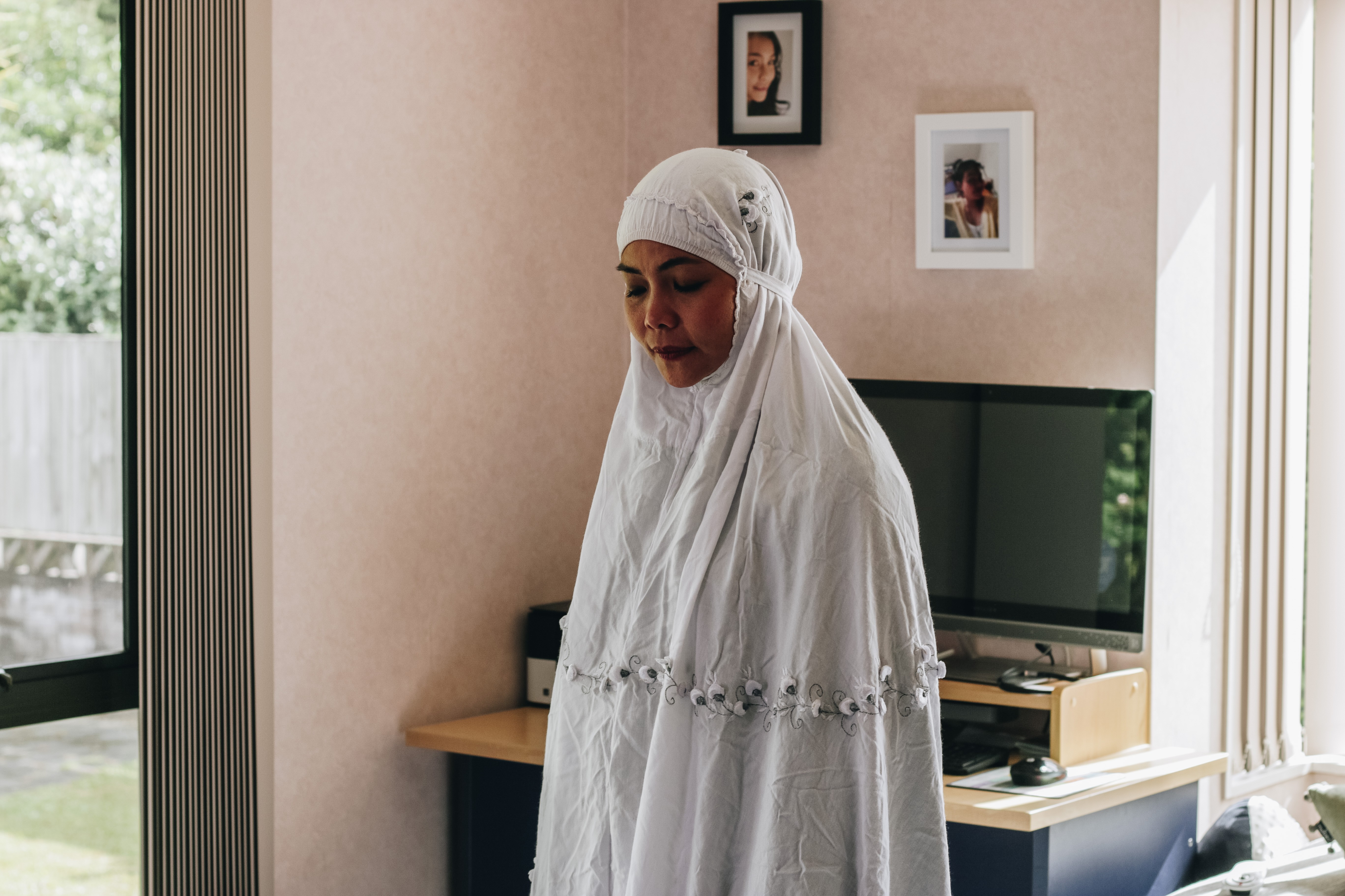 In a scene from 'This Is Us', a woman wearing a white khimar prays in her living room