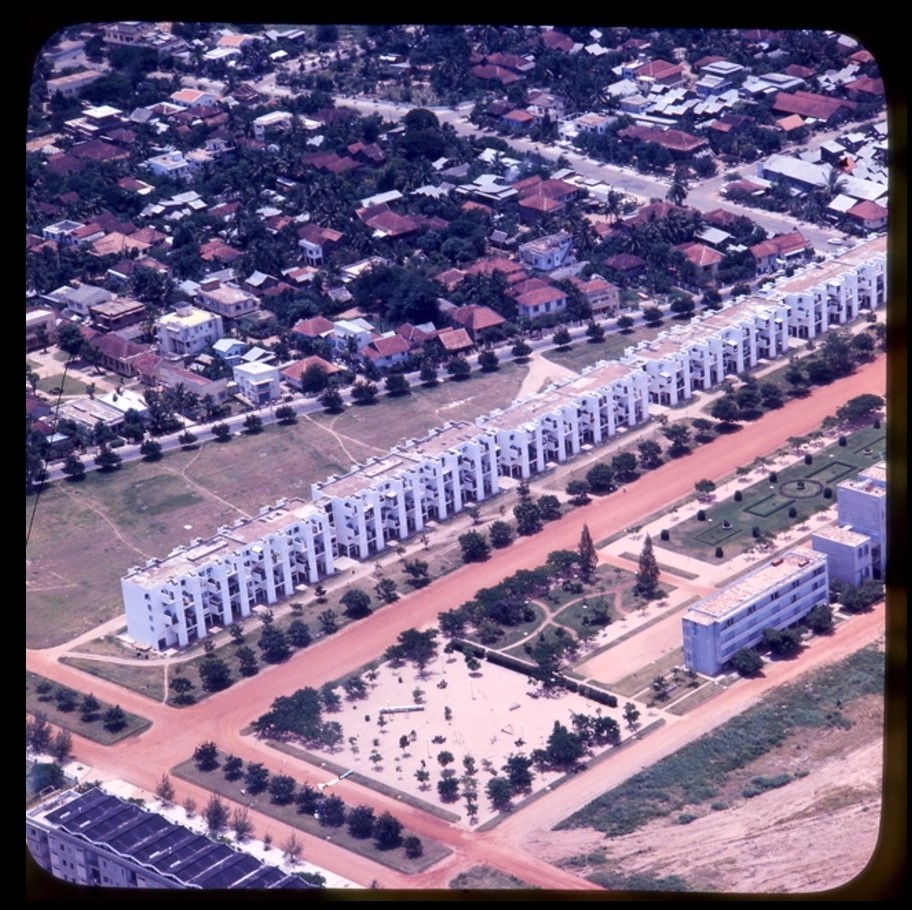 Aerial photo of a long white modernist apartment building 