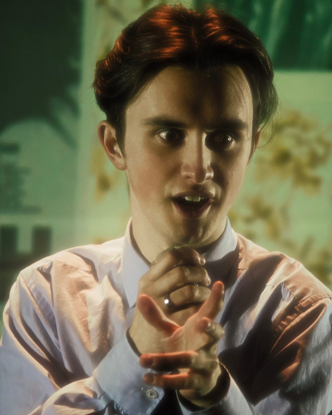 Man with a shocked expression wearing a lavender button-down  