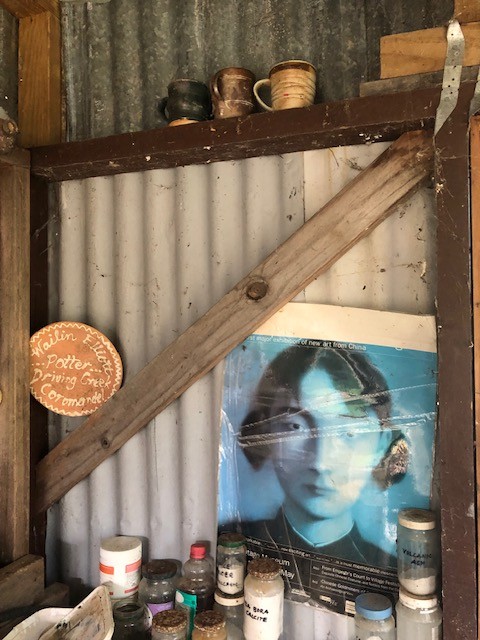 View of an old photograph of a woman with other artist materials around it in a corrugated iron studio.