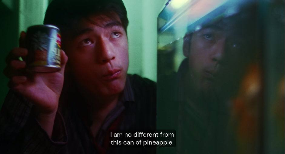 Tony Leung holds up a can of pineapple and looks upwards.