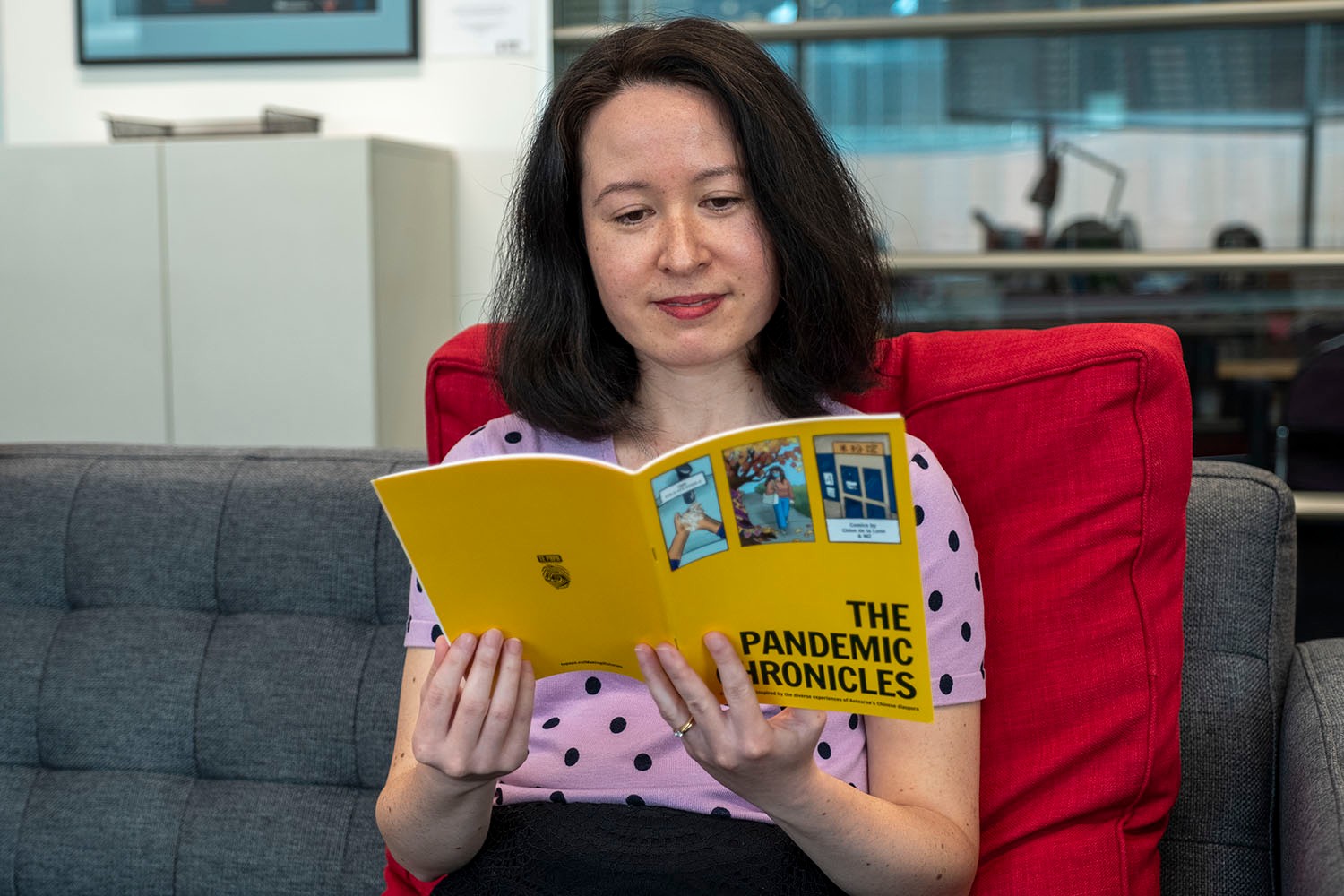 A person reading a yellow zine and smiling.