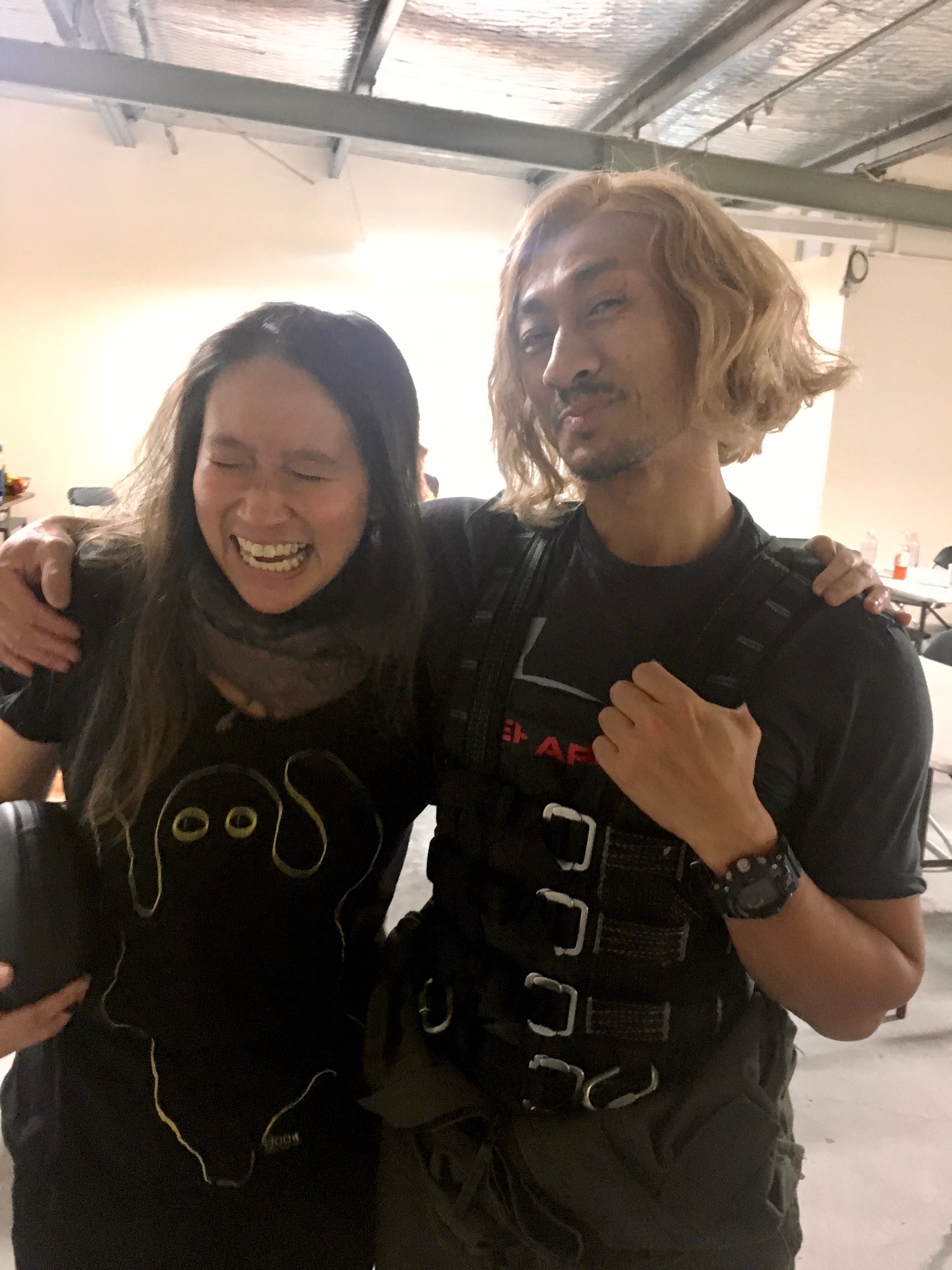 A Chinese woman laughing while an actor puts his arm around her