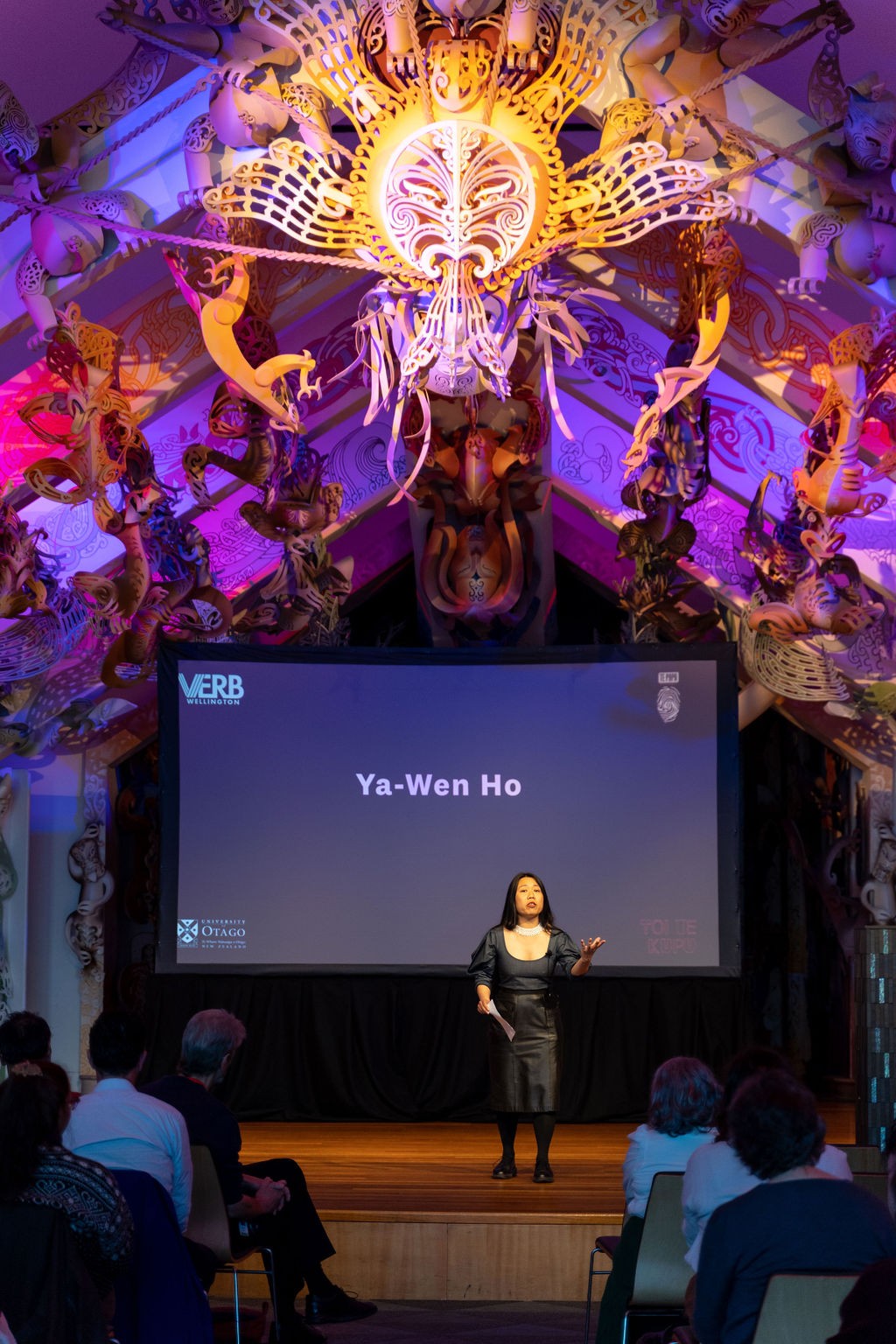 A person on stage speaking.