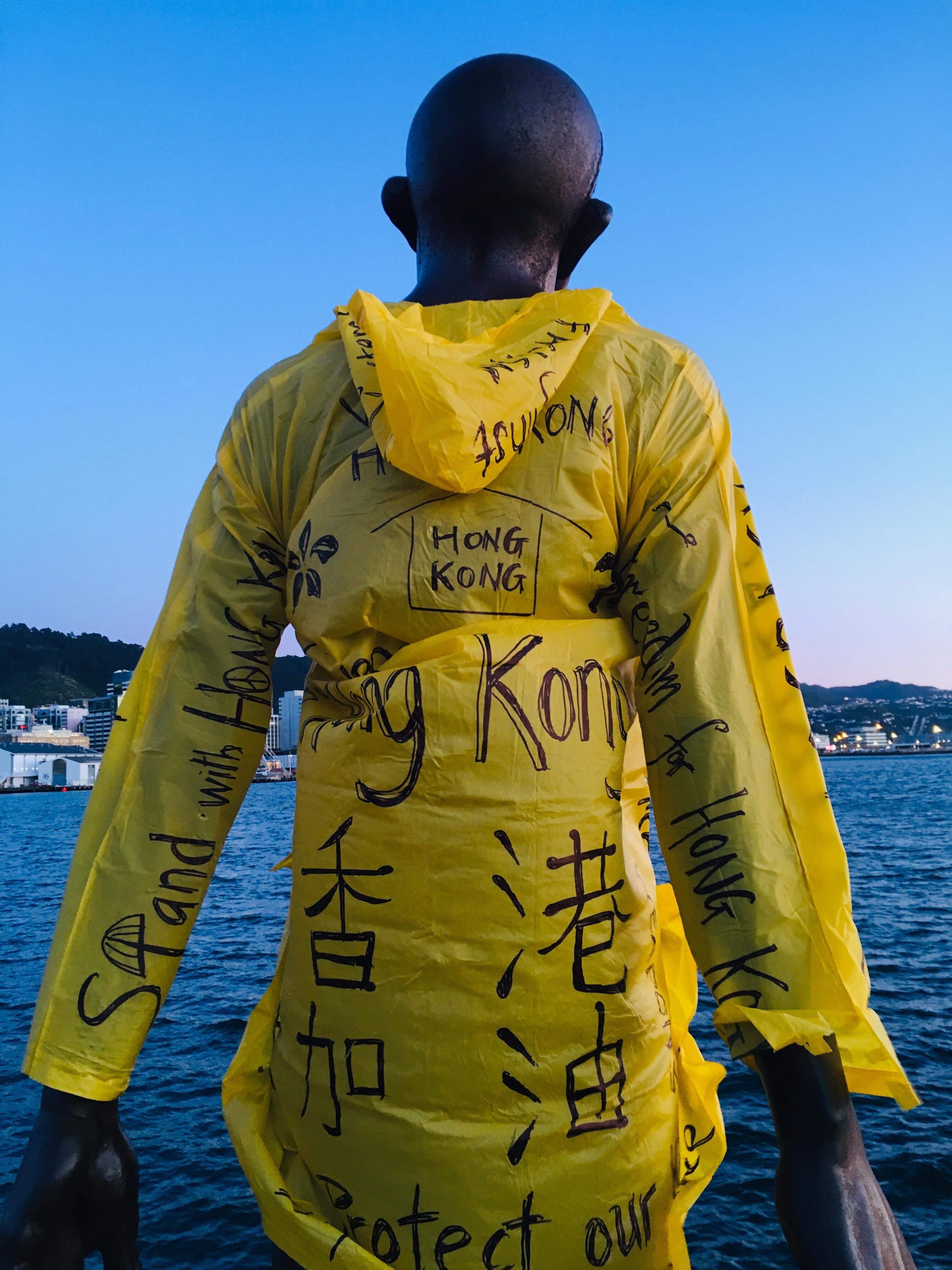 A bronze statue facing Wellington harbour has been dressed in a yellow raincoat with handwritten Free Hong Kong messages on it.