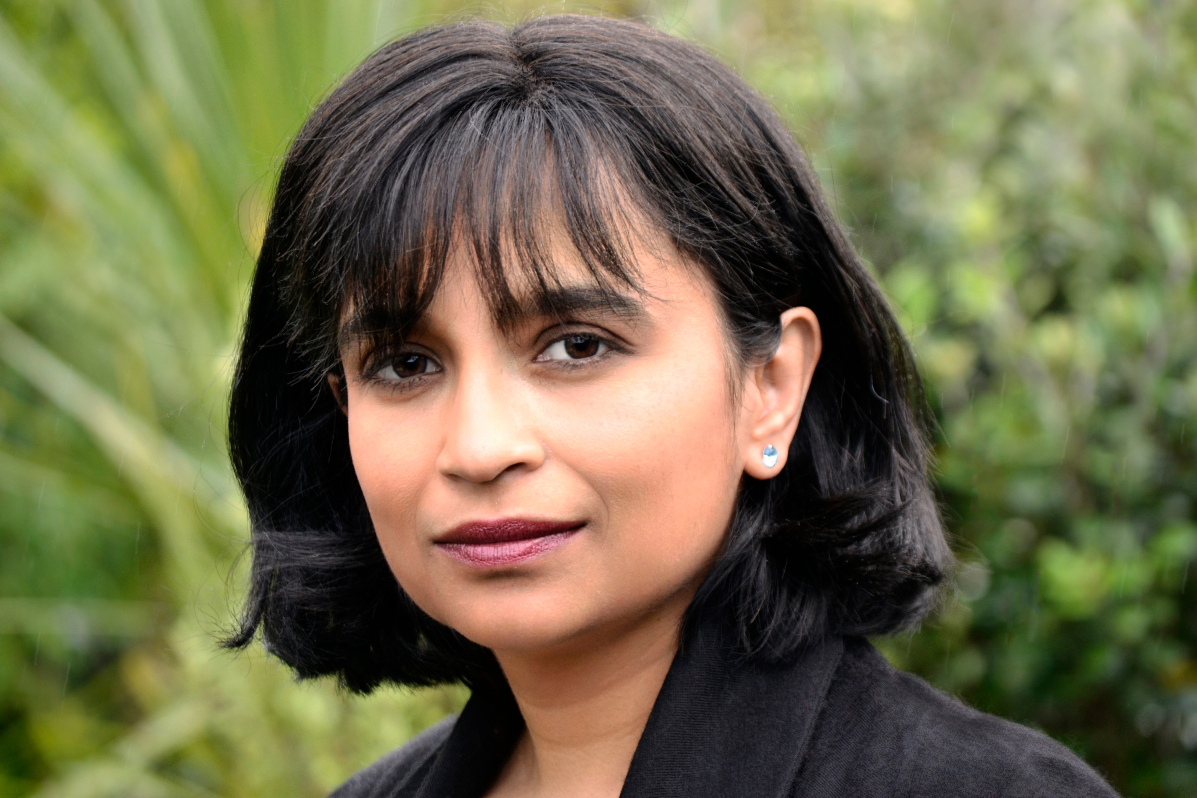 A close-up of a woman with a black bob and fringe looking directly into the camera 