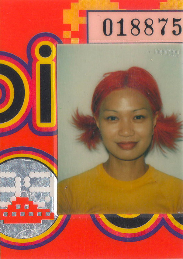 Close up of the pass with a passport-style photo with a woman in red pigtails and a yellow shirt
