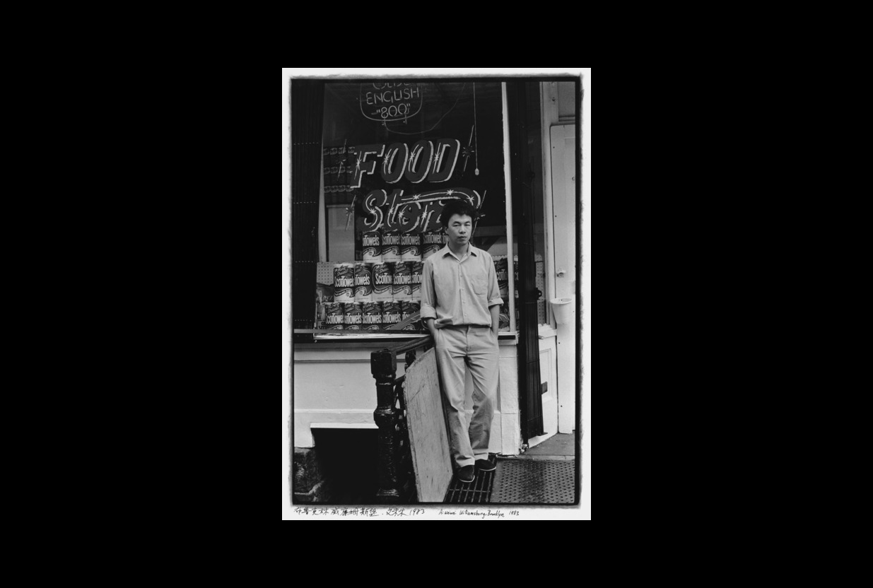 A young Chinese man stands in front of a food store.