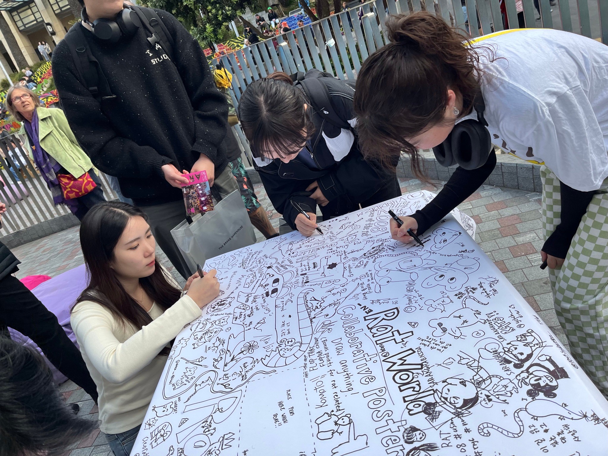 People add to a large collaborative drawing.