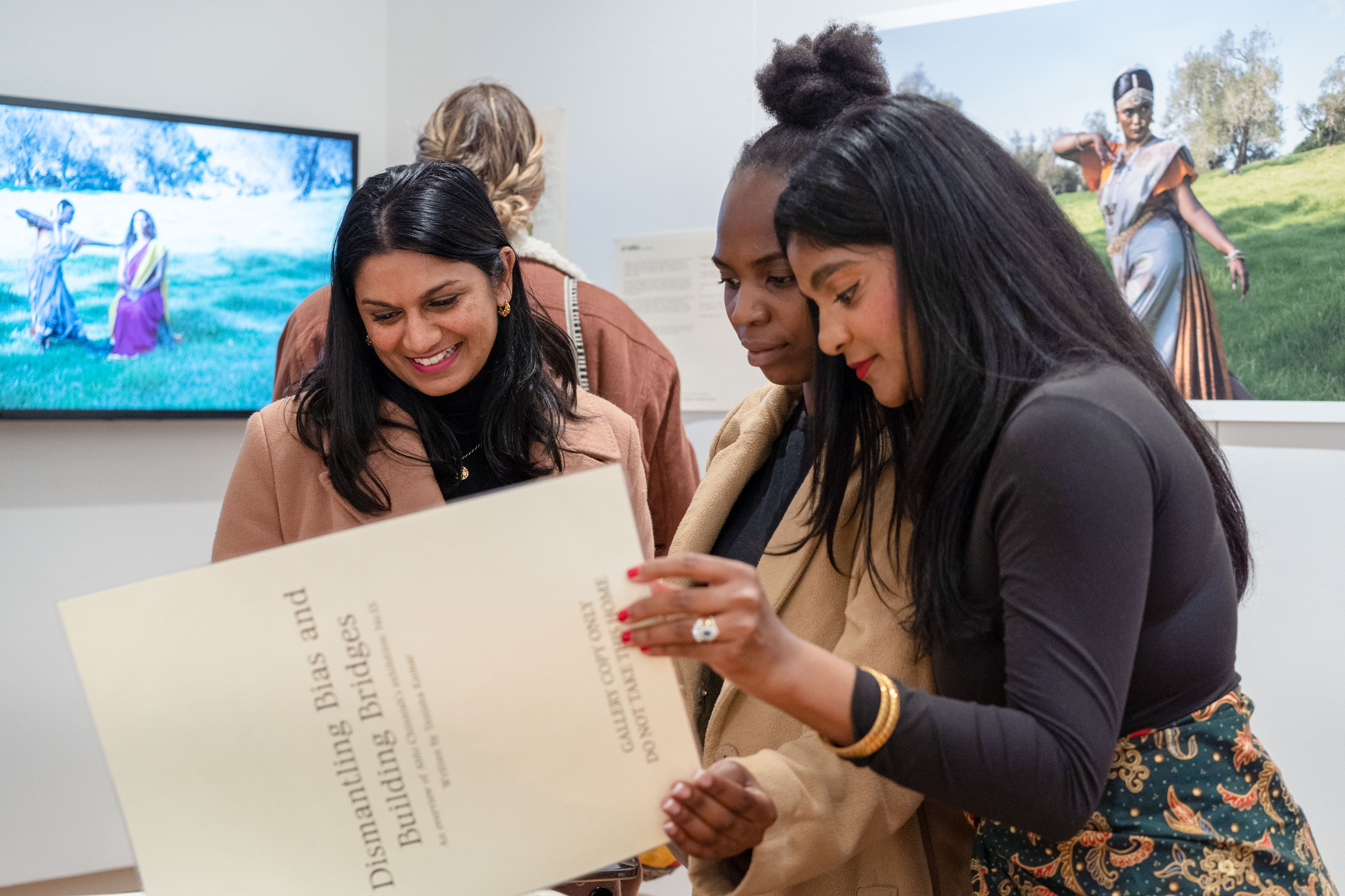 Three people reading a book together