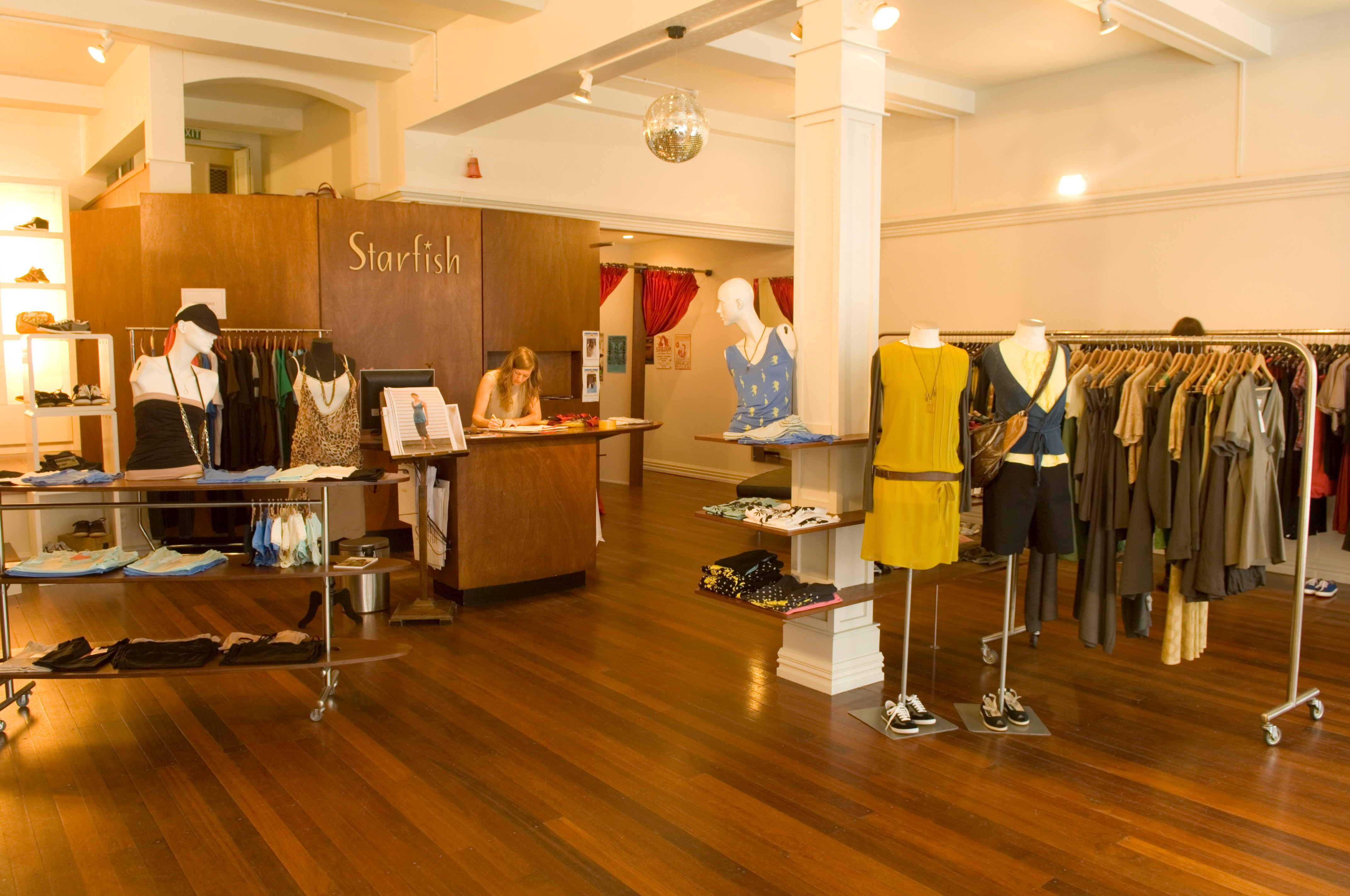 Interior of a spacious Starfish clothing store with wooden floors and racks of garments.