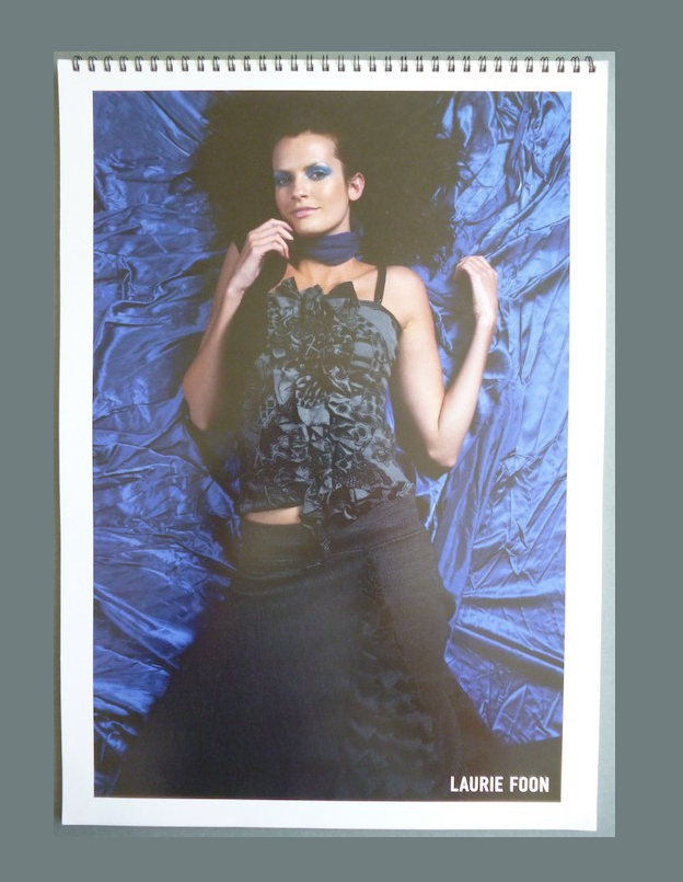 A spiral bound book of showcards with models in a fashion shoot.