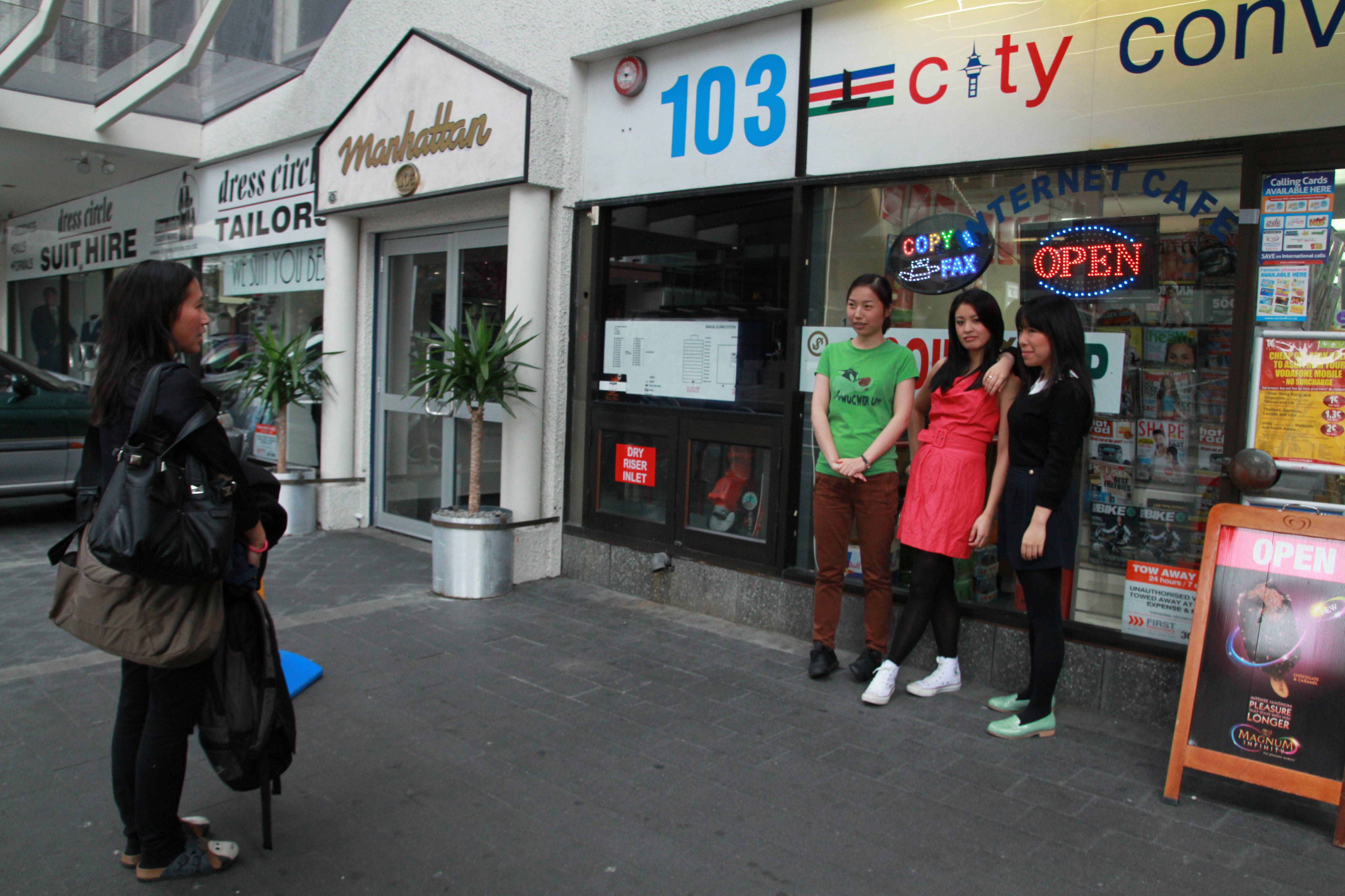 Three East Asian women stand in front of a dairy