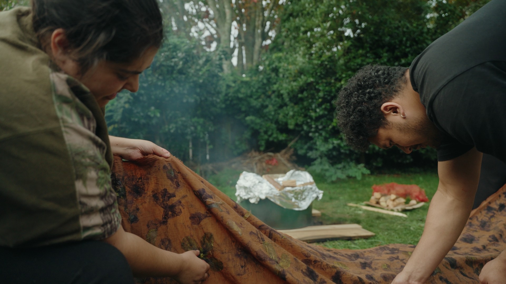 A garden smoking with two people marking fabric