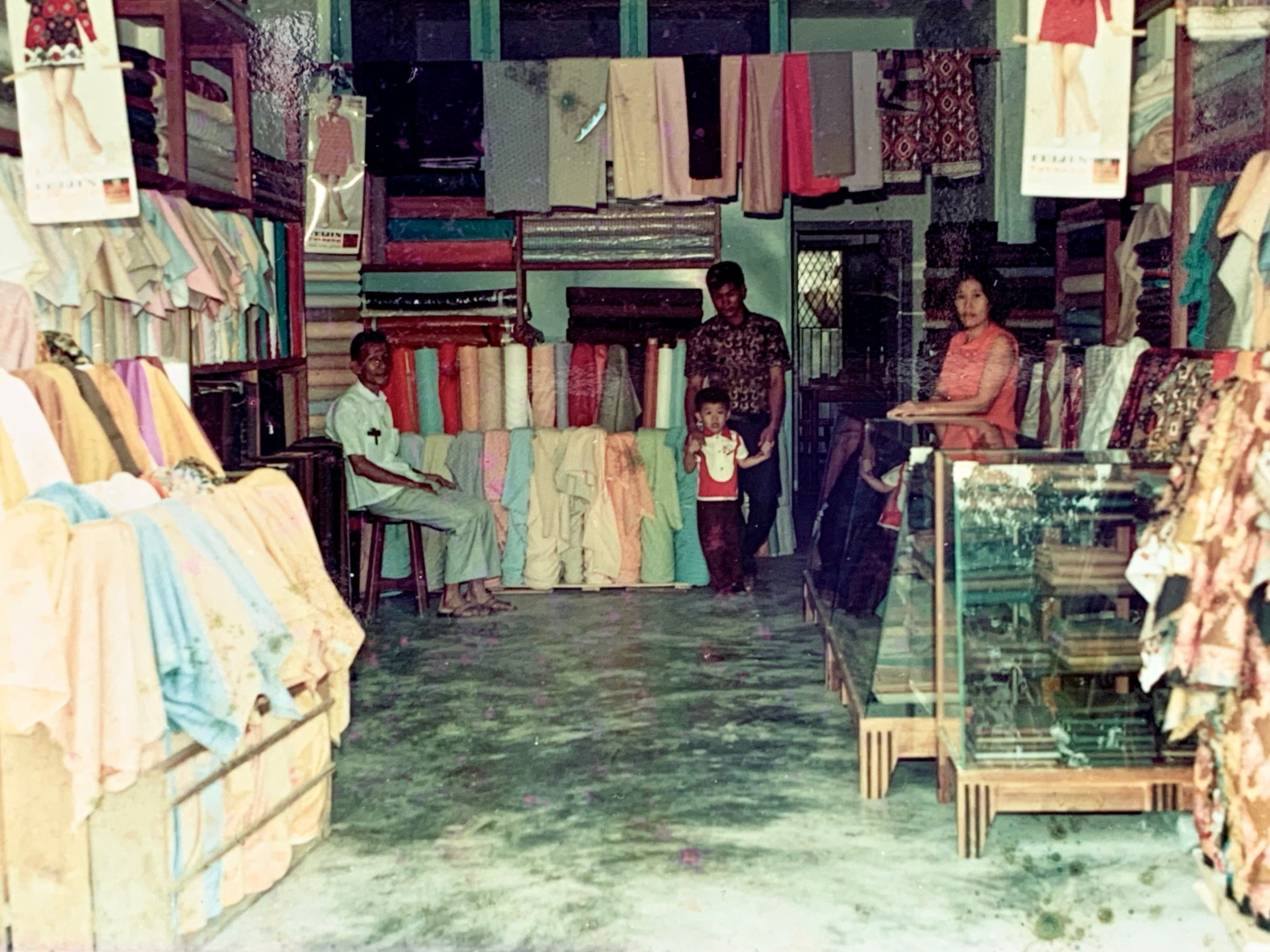 Photograph of a fabric shop with fabrics hanging and displayed around the perimeter.