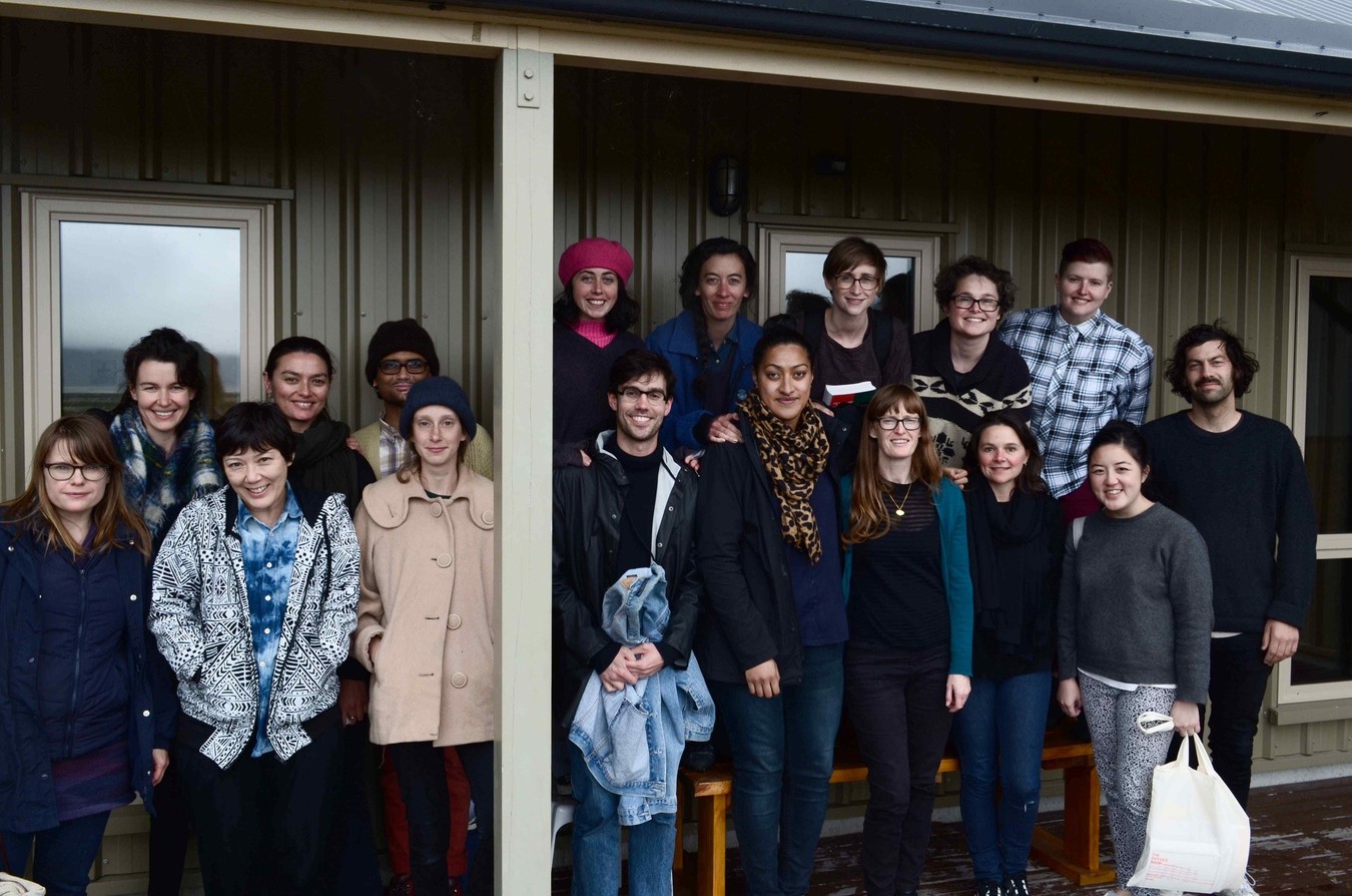 A group photo outside an alpine lodge.