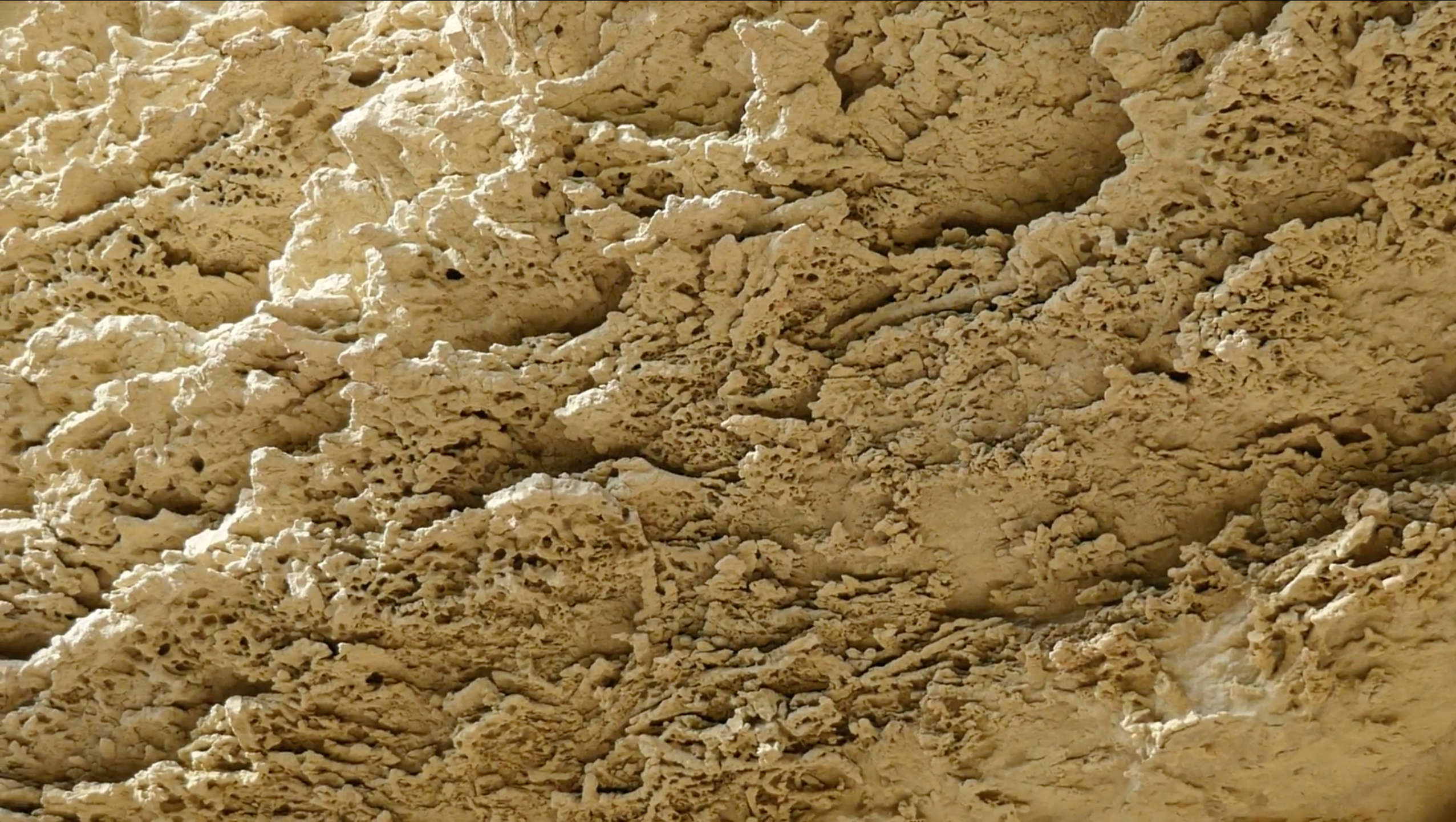 Still from a vide of limestone formations in a creamy yellow