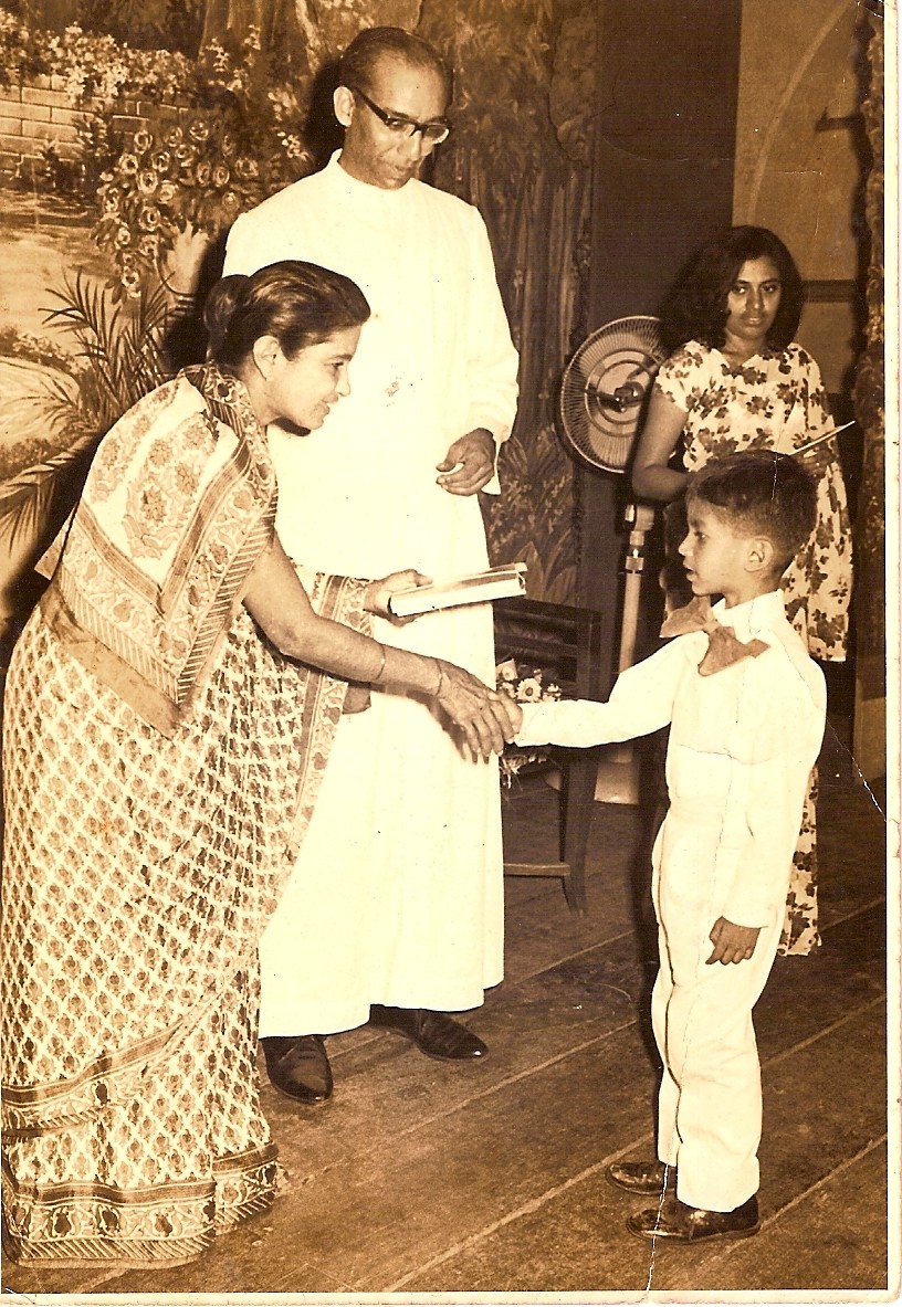 A child receiving an award by a women in a saree