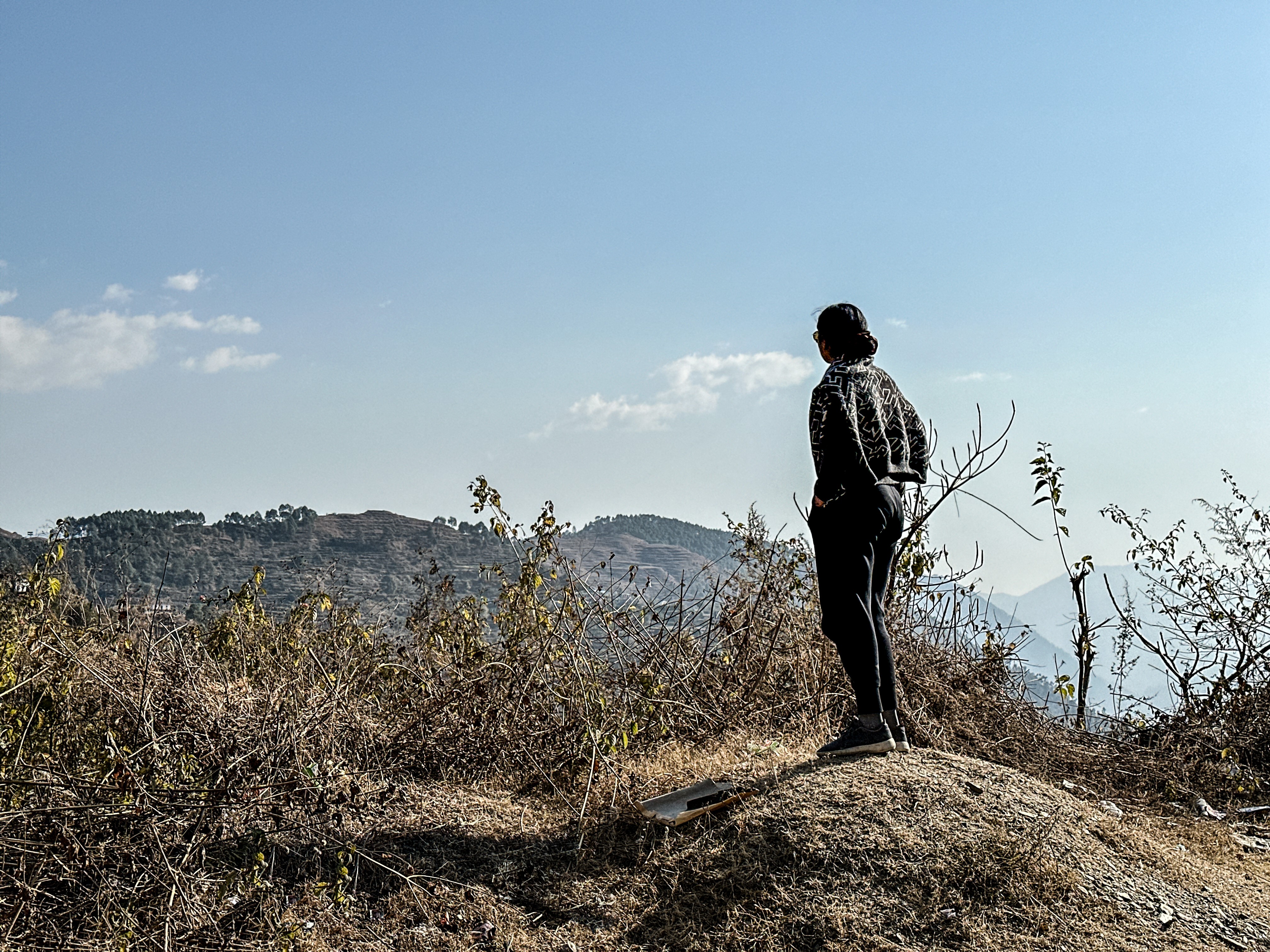 Ankita standing looking out over some hills.