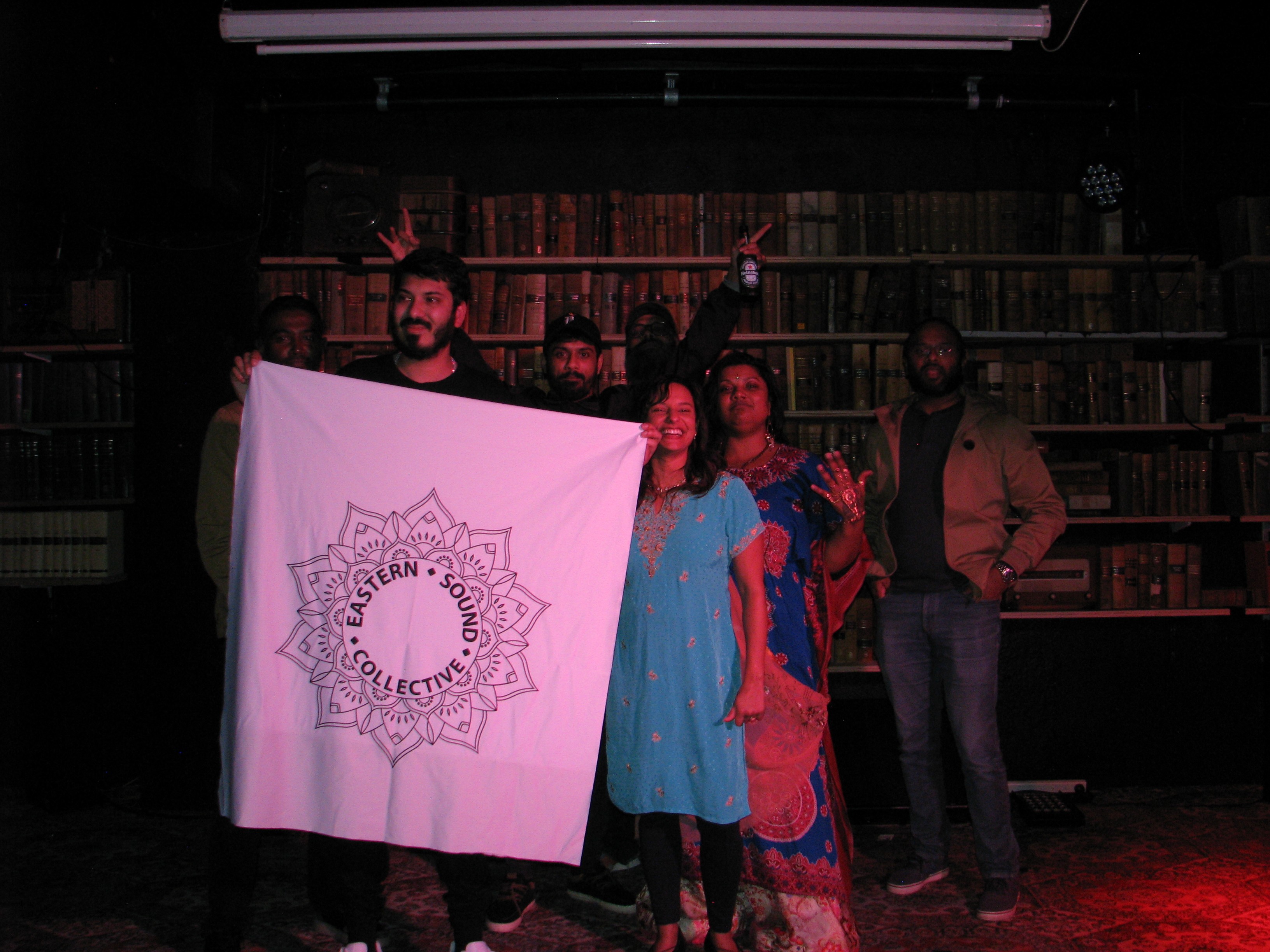 A group of people holding a banner featuring the Eastern Sound Collective logo