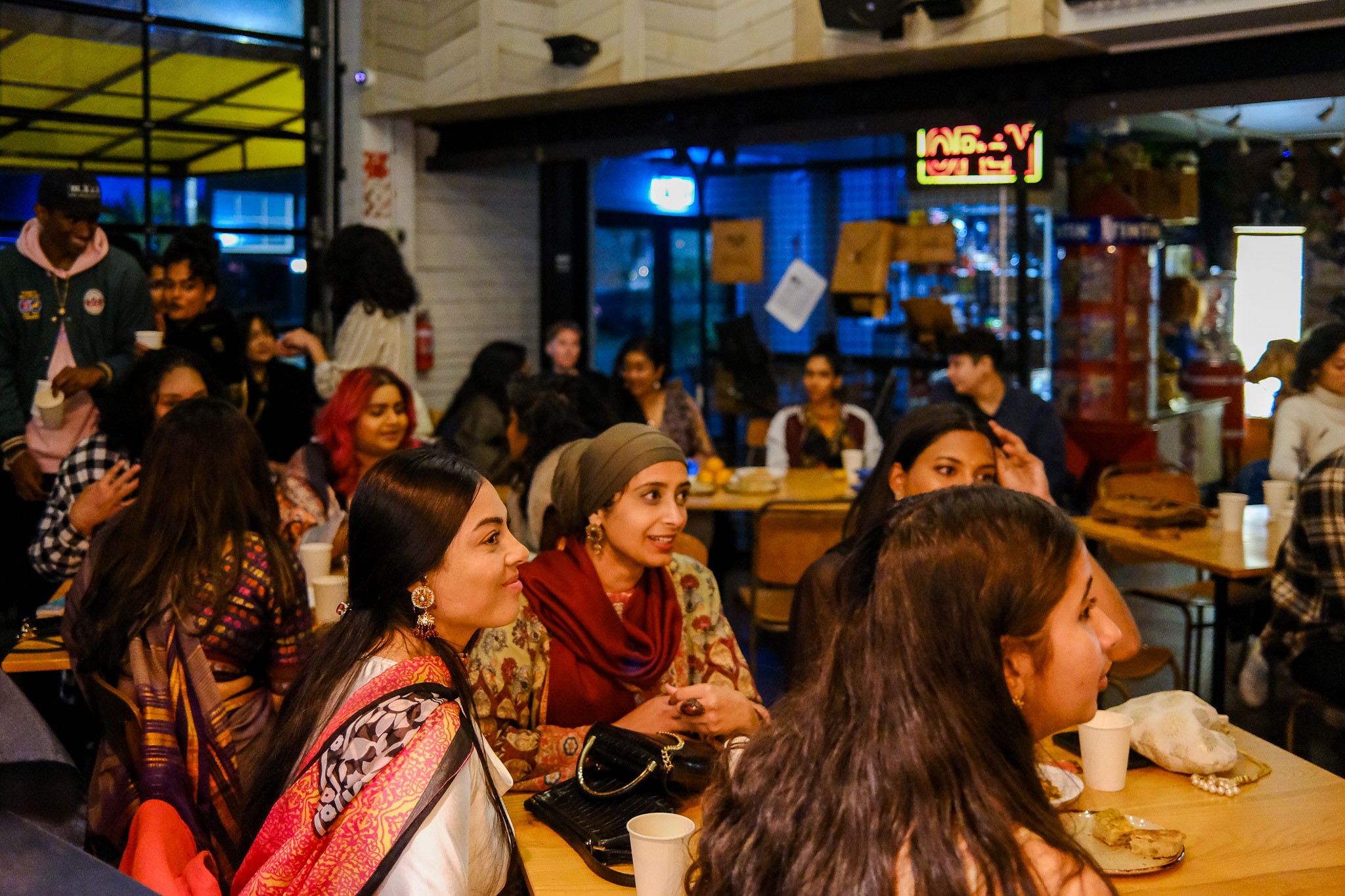 A crowded room with people sitting at tables