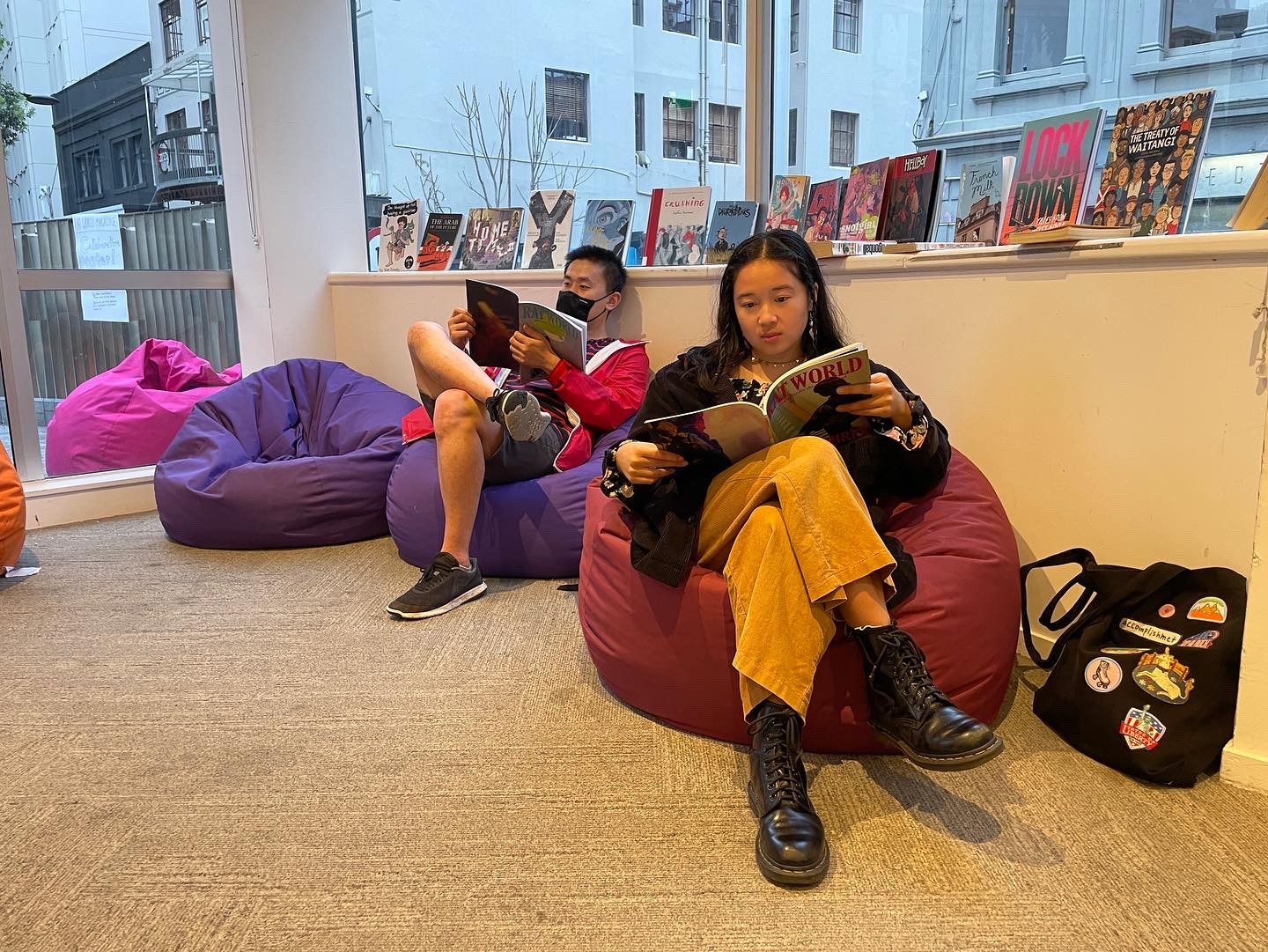 Two people on beanbags reading Rat World.