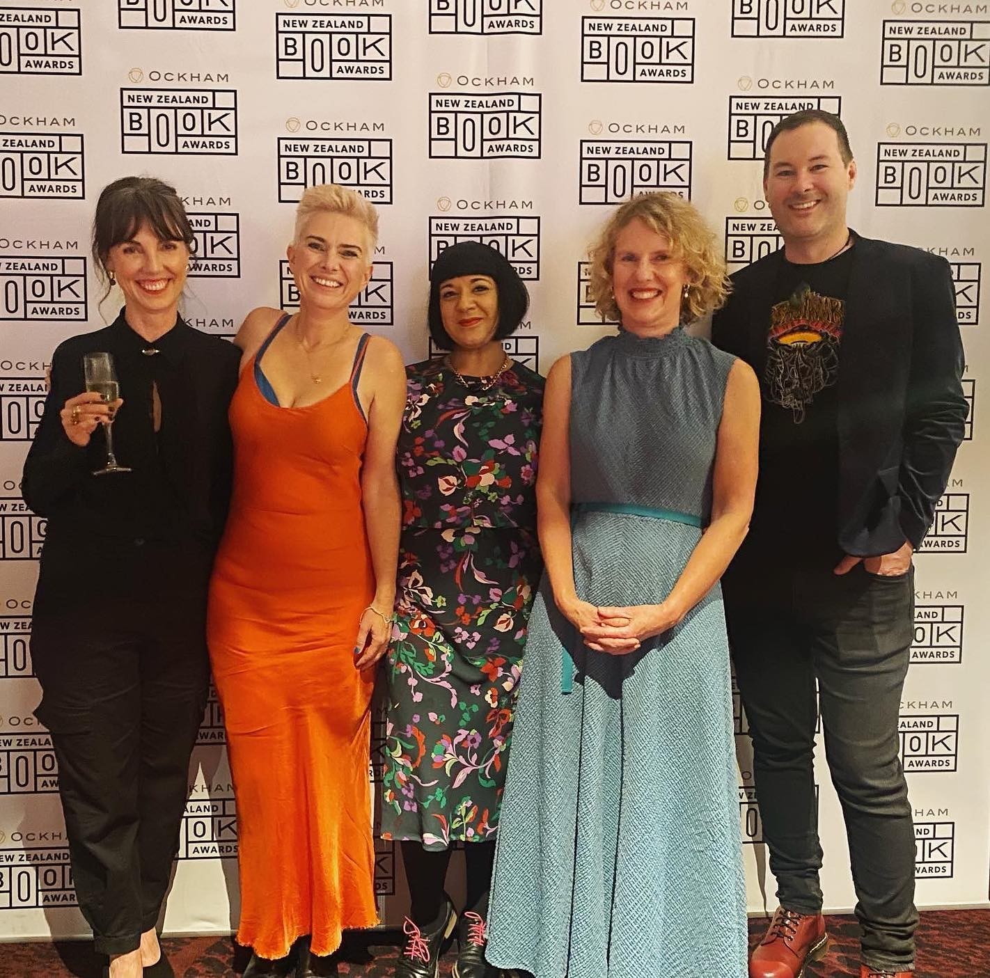 Four people posing on a red carpet
