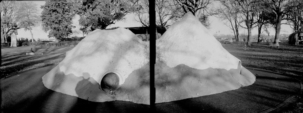Black and white diptych photograph  of a mountain-shaped playground feature. 