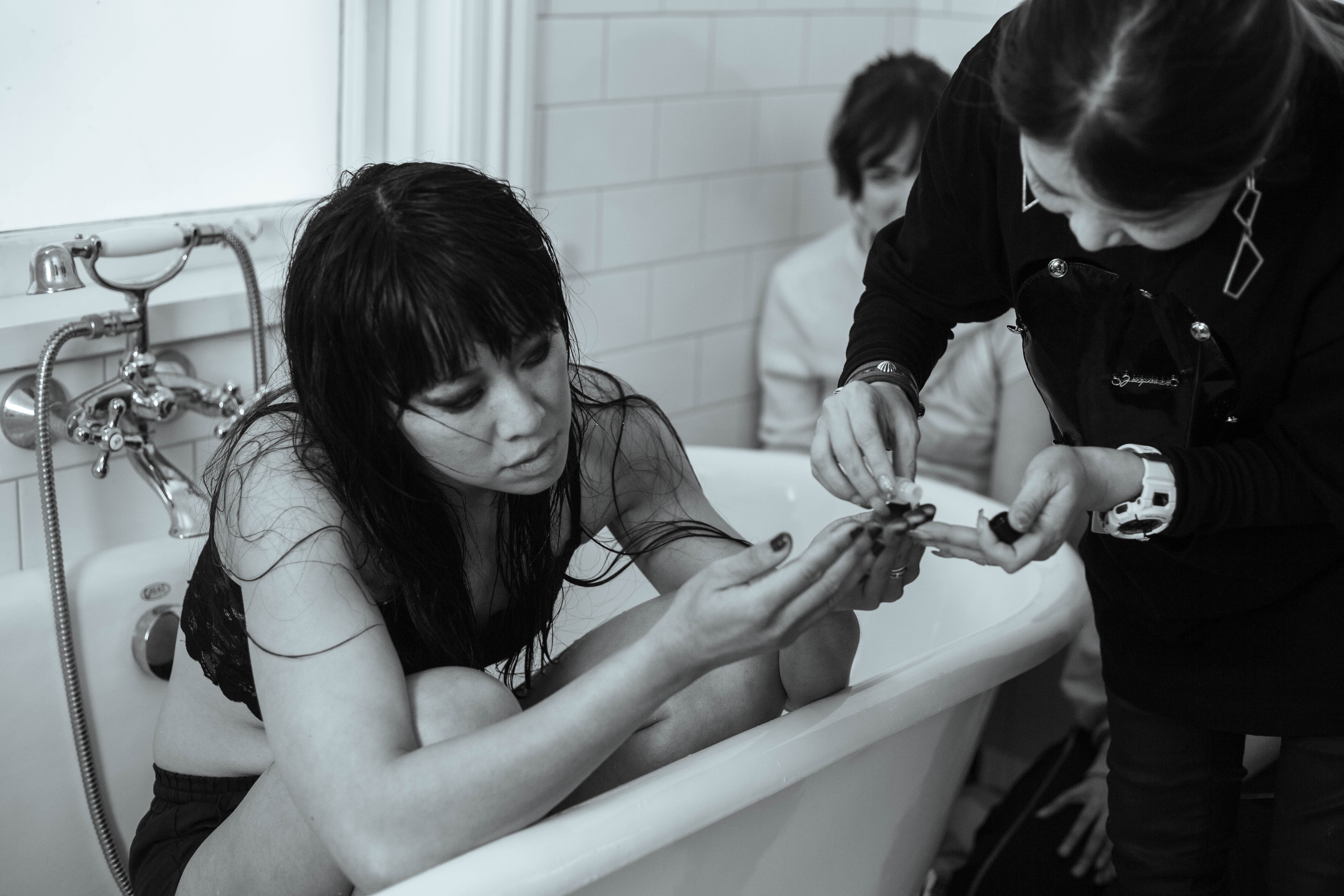 A black and white image of a woman in a bathtub