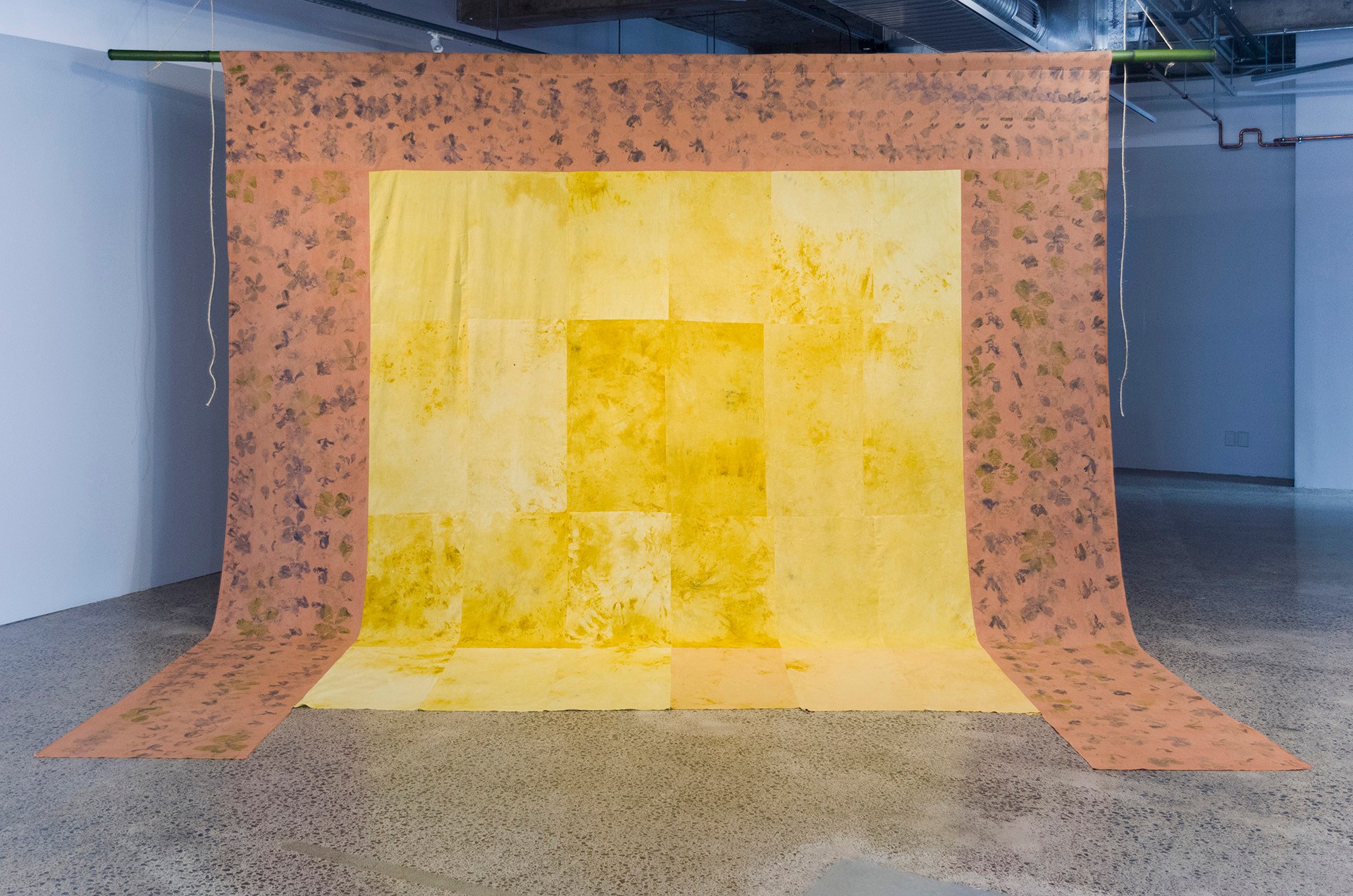 Large textile installation, interior is yellow with patterned apricot surrounding three sides