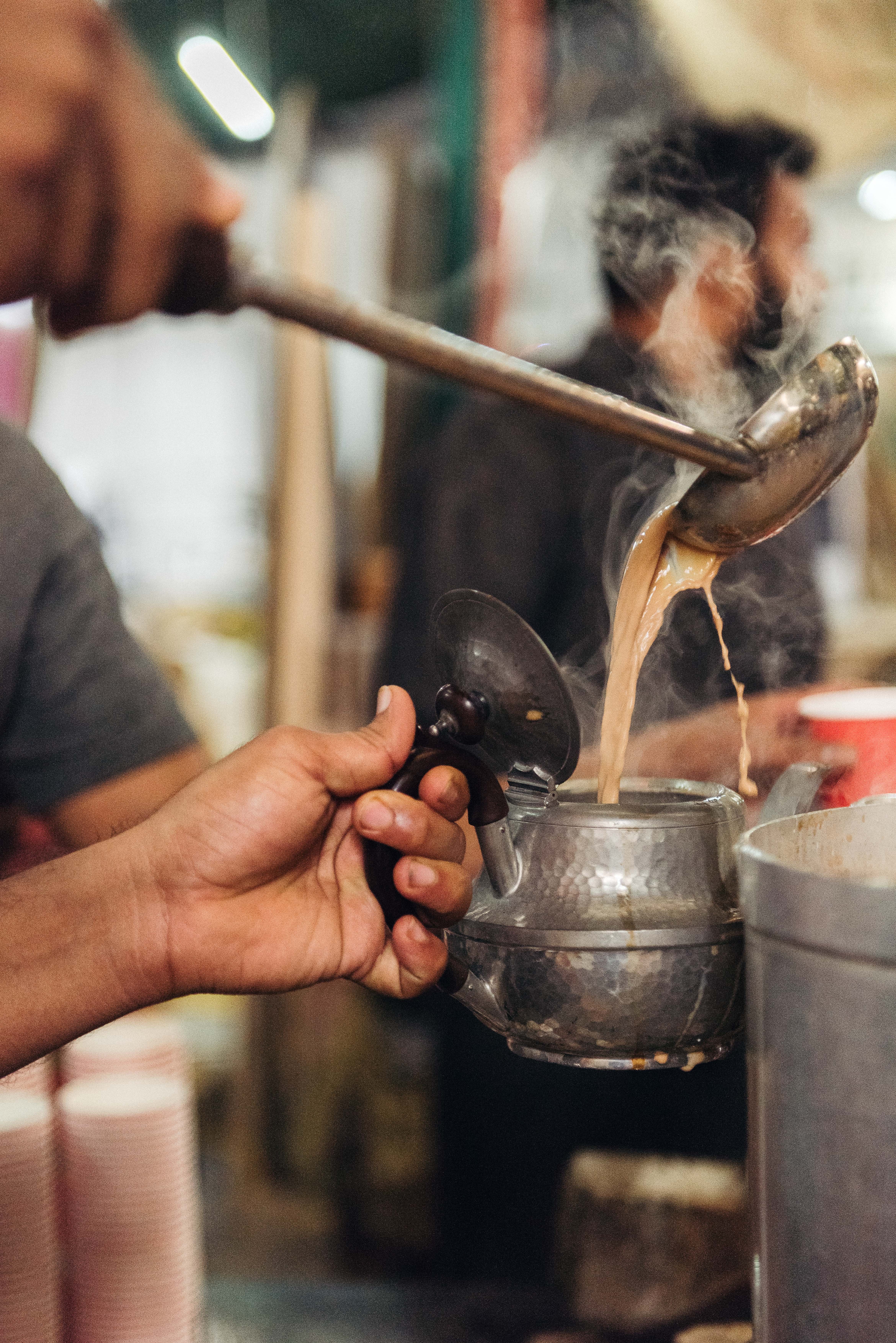 Tea being poured into a silver jug