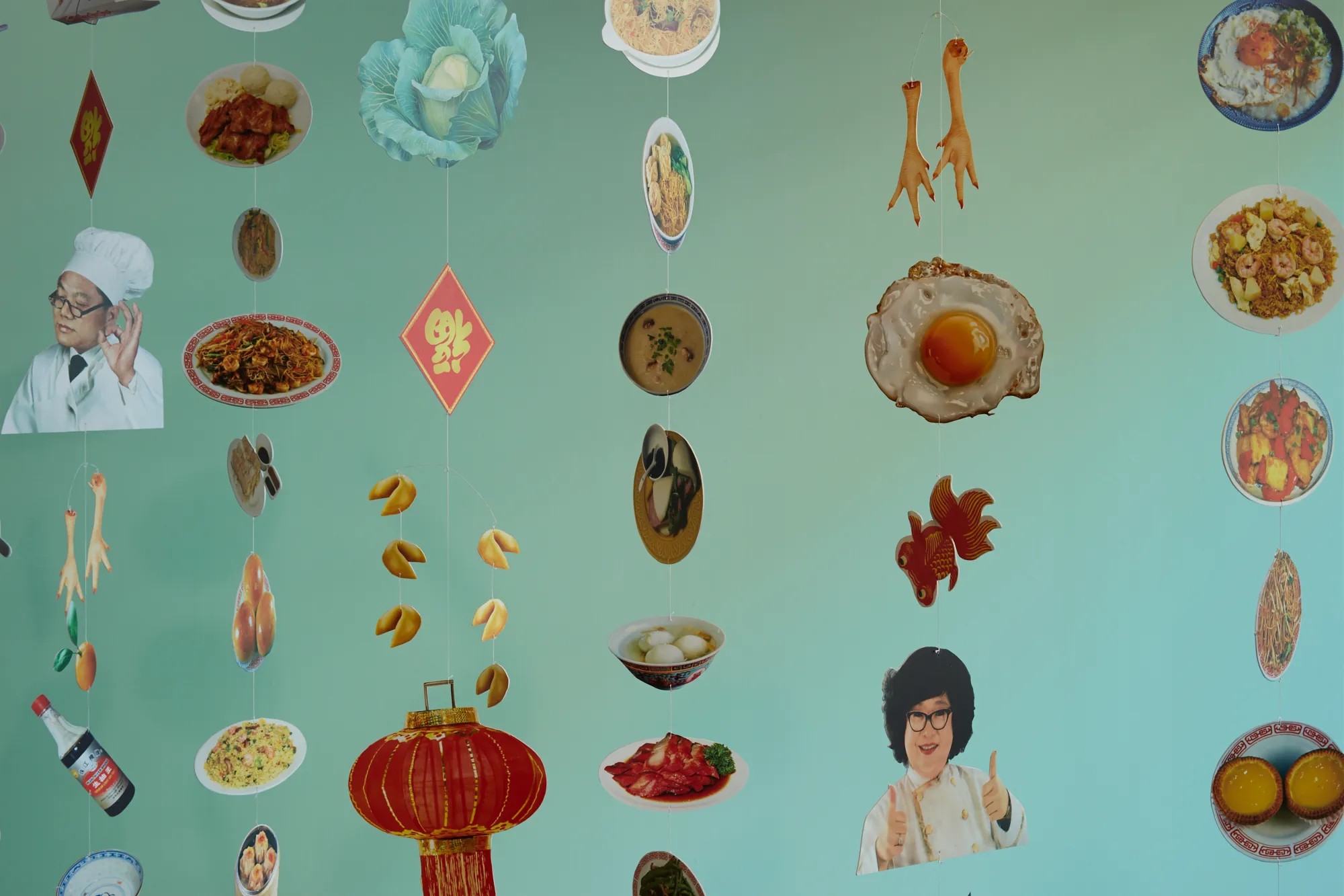 Hanging diorama featuring different chinese foods like a fried egg, fortune cookies, and fried rice
