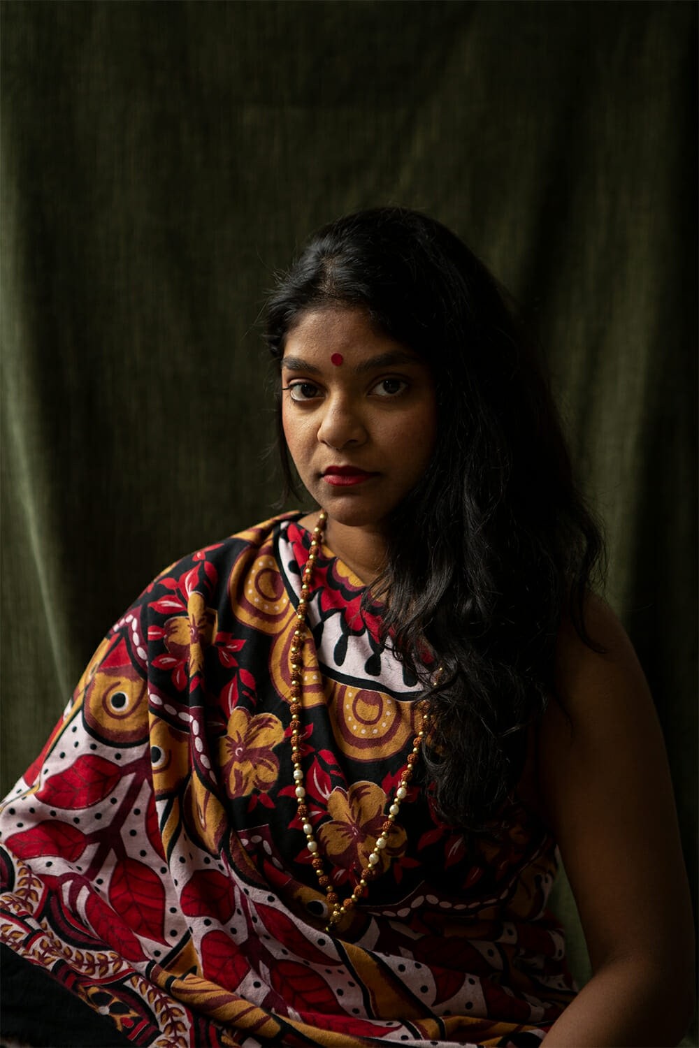 A portrait of a woman in front of a green background