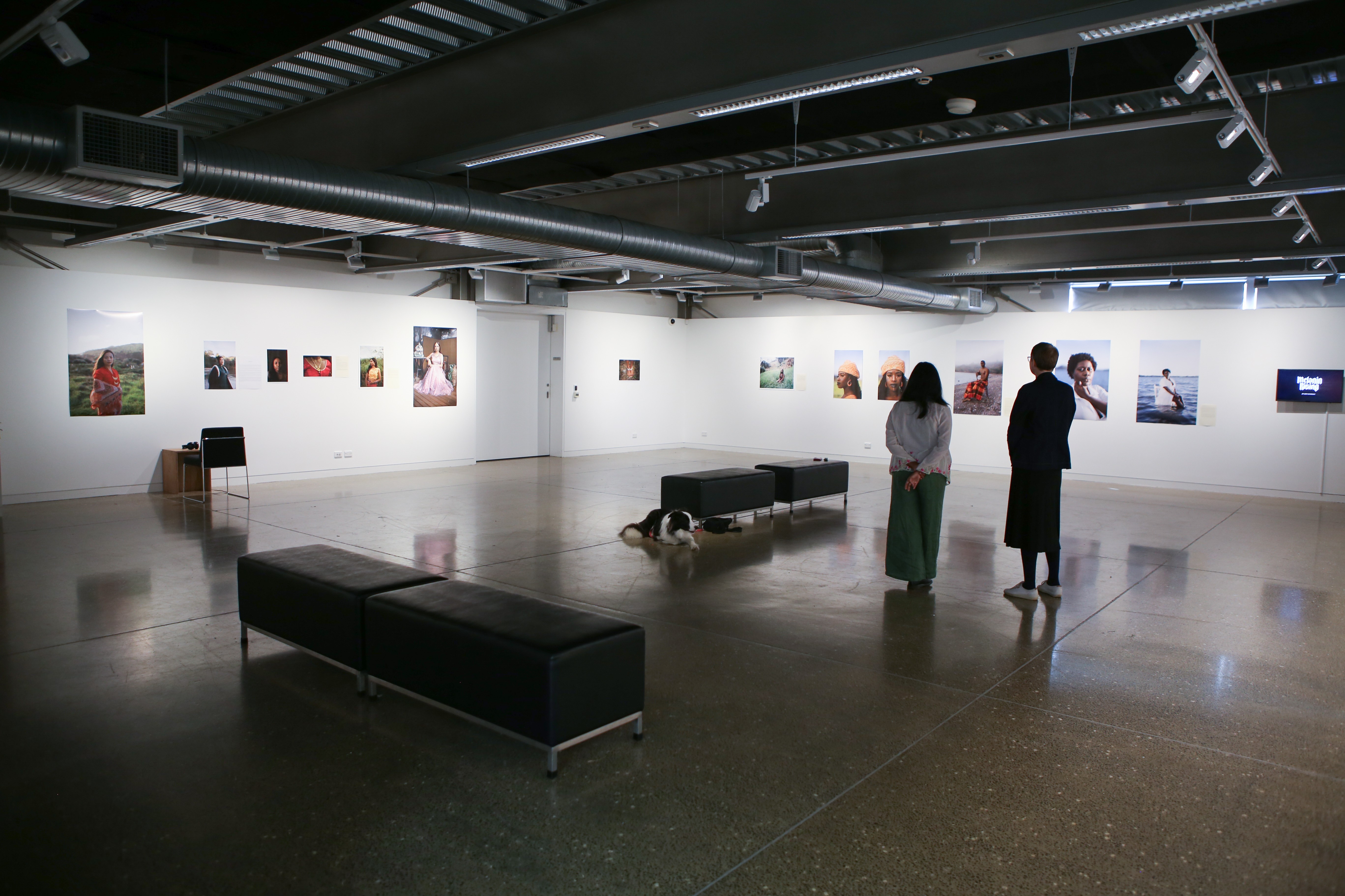 Two people viewing a photography exhibition