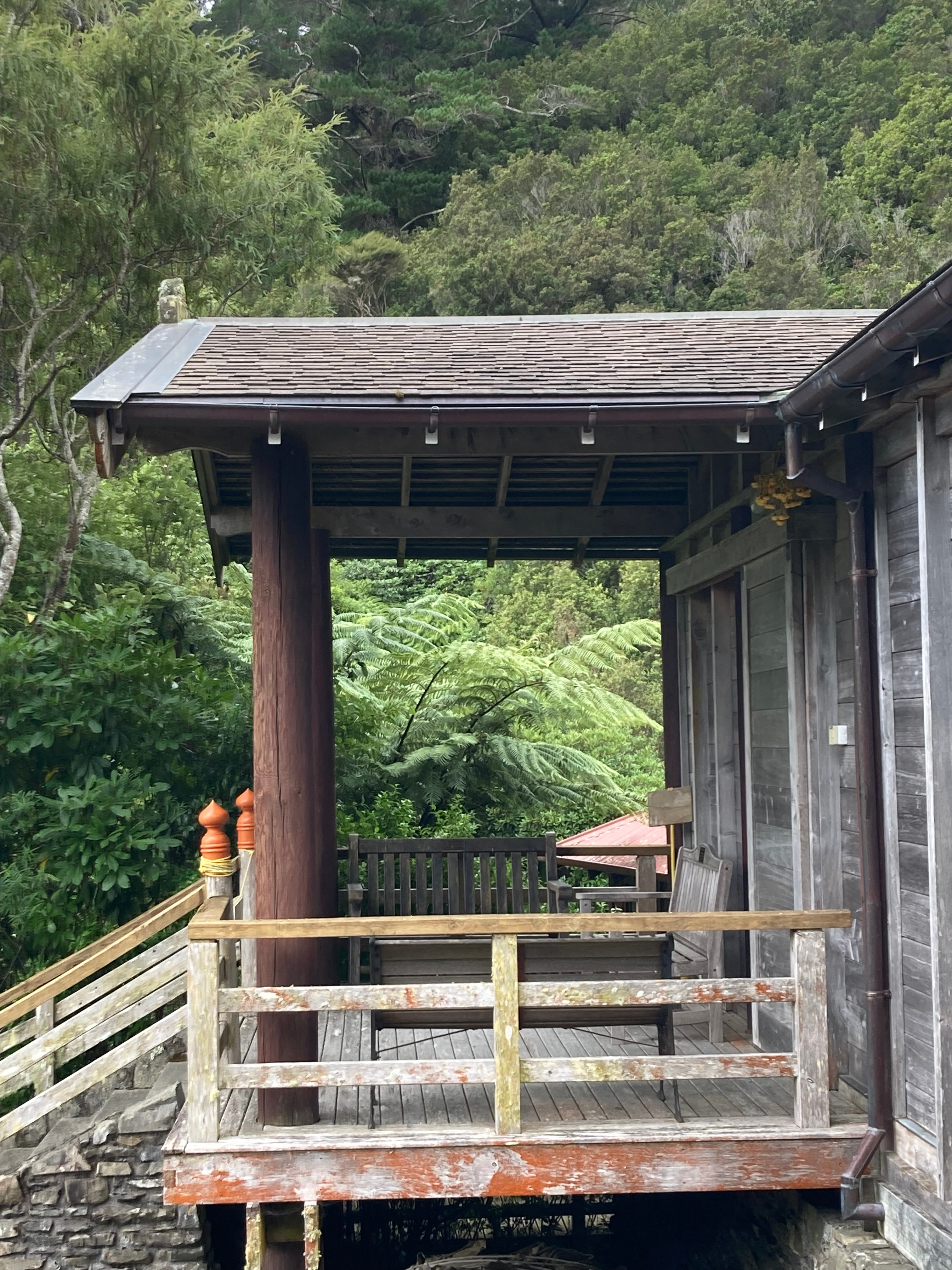 Entrance to a Buddhist monastery building against green bush.