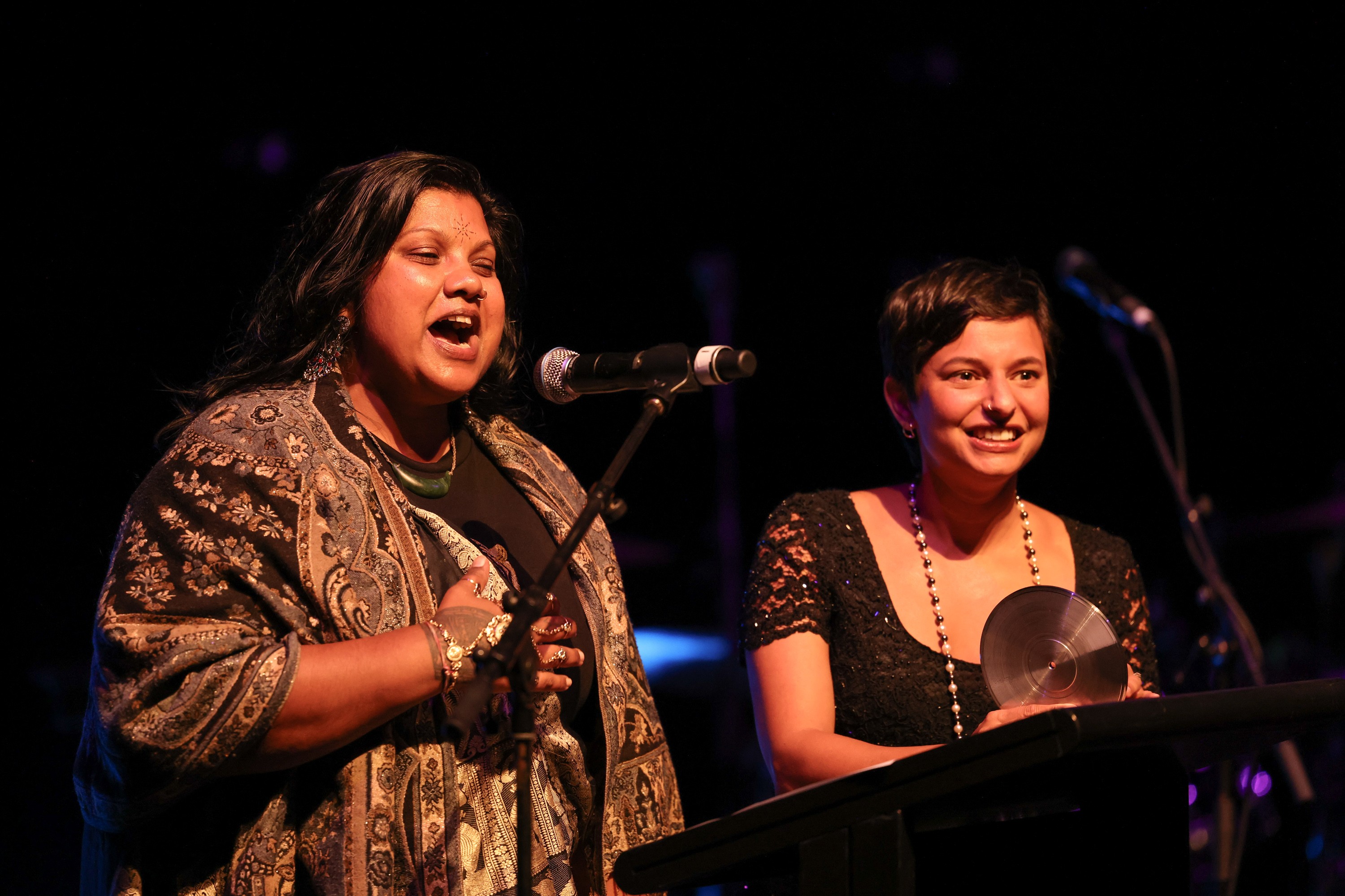 Two people in front of microphones