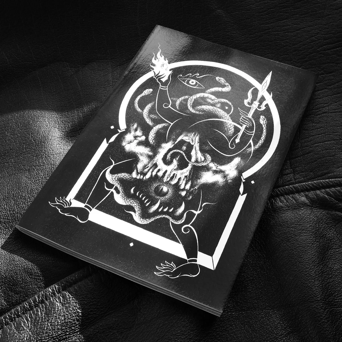 A black cover of a zine with a white abstract illustration 